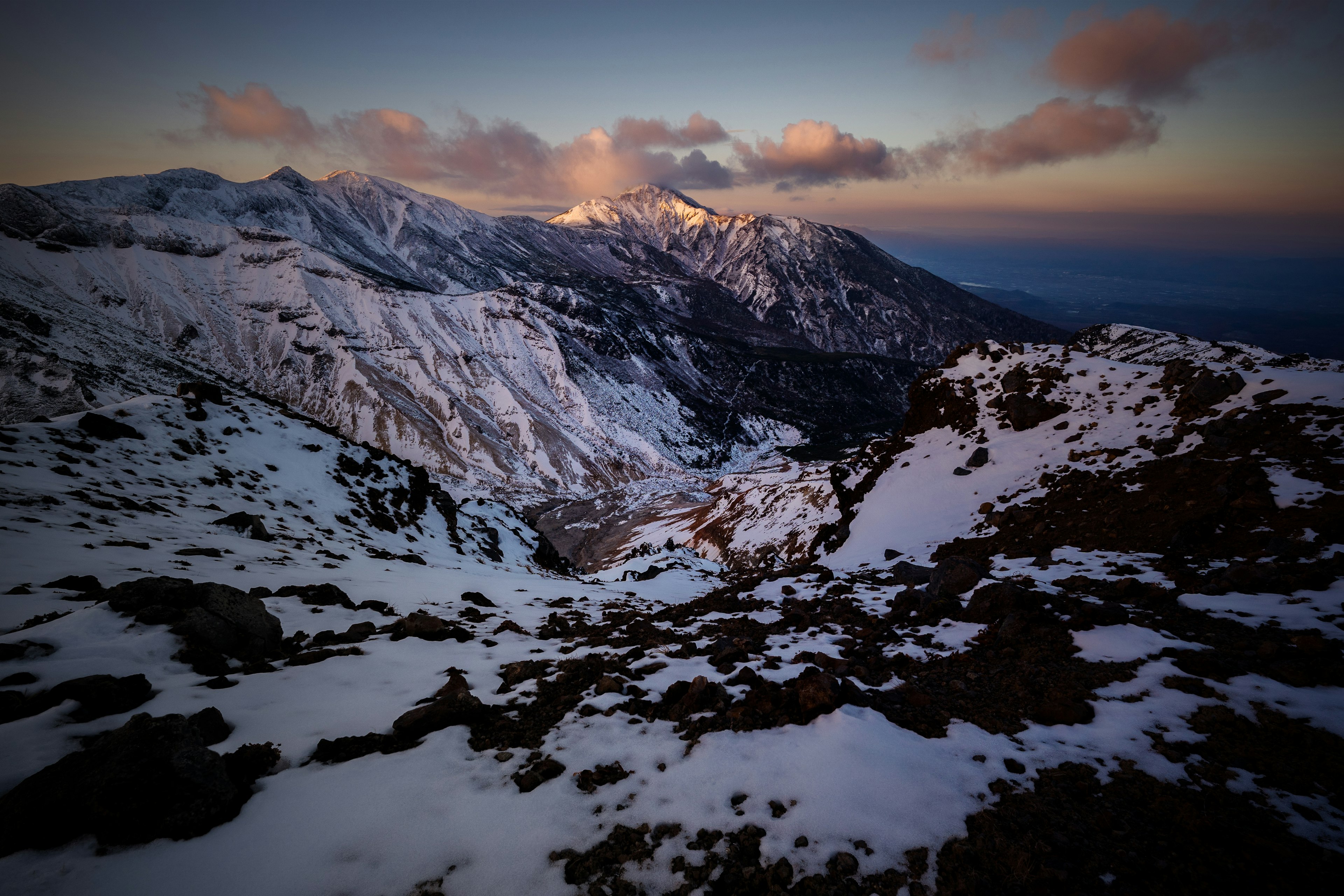 雪に覆われた山々と夕暮れの空