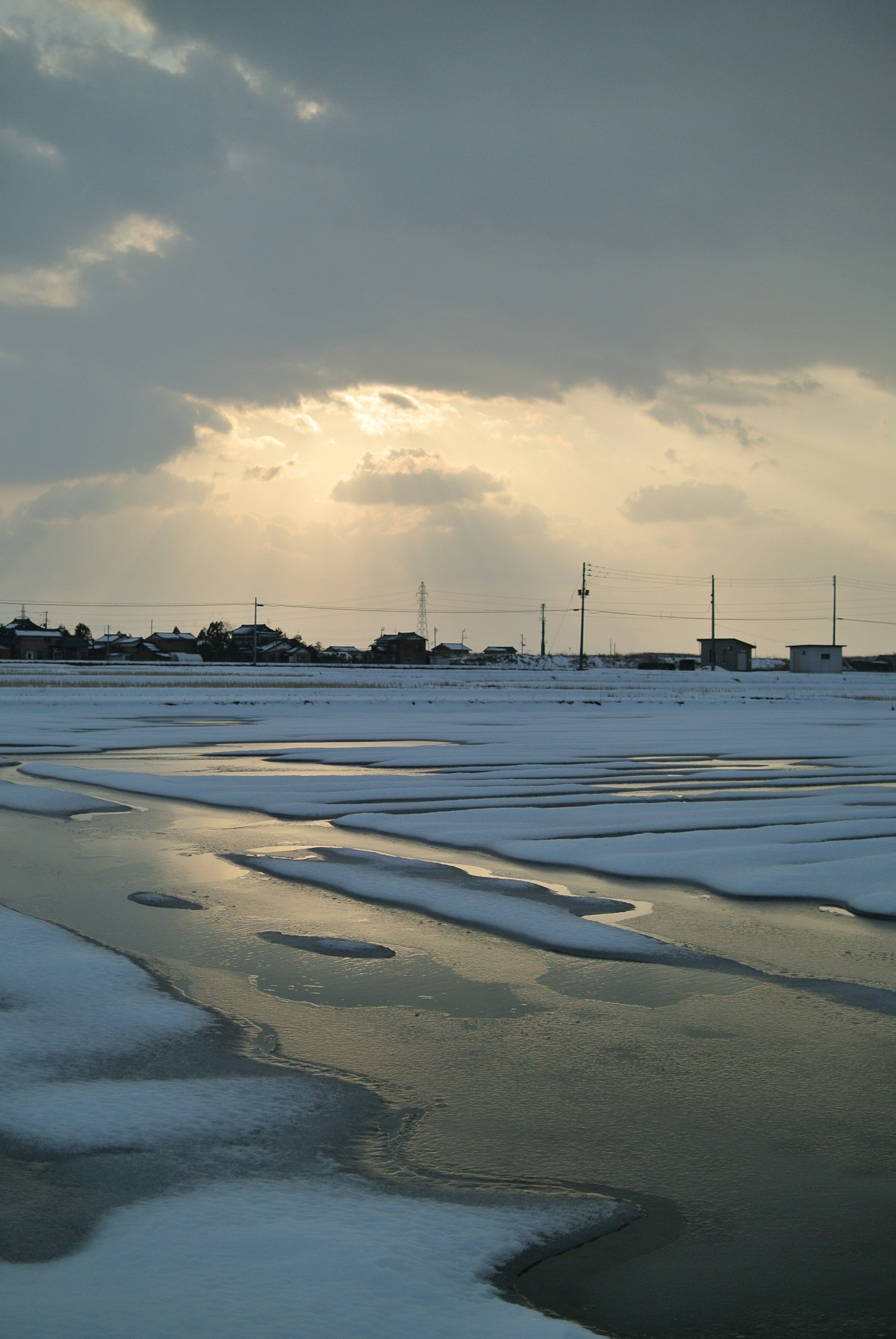 Paisaje cubierto de nieve con cielo oscuro y superficie de agua reflectante