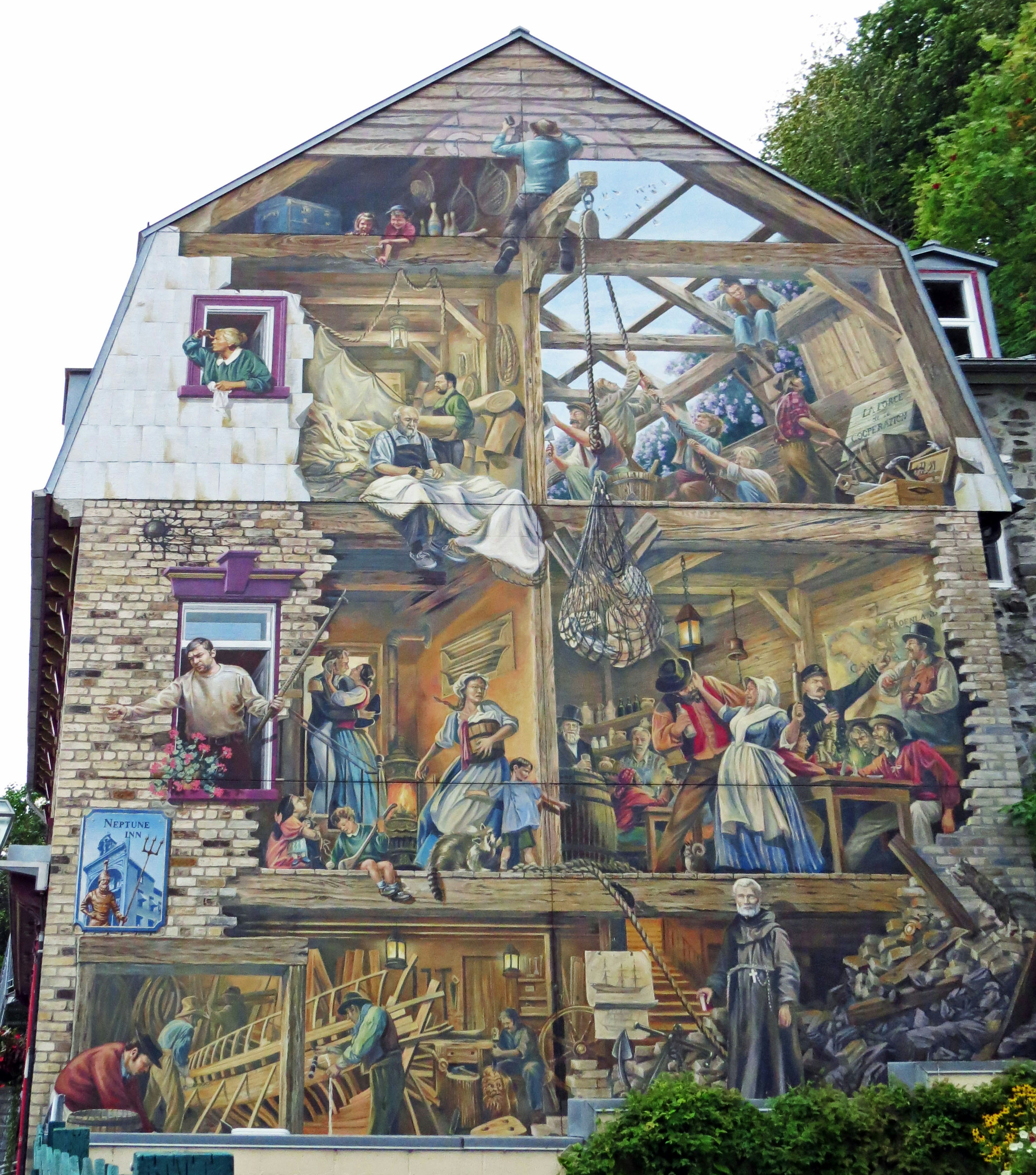 Detailed mural on a house wall depicting scenes of a workshop and people's activities