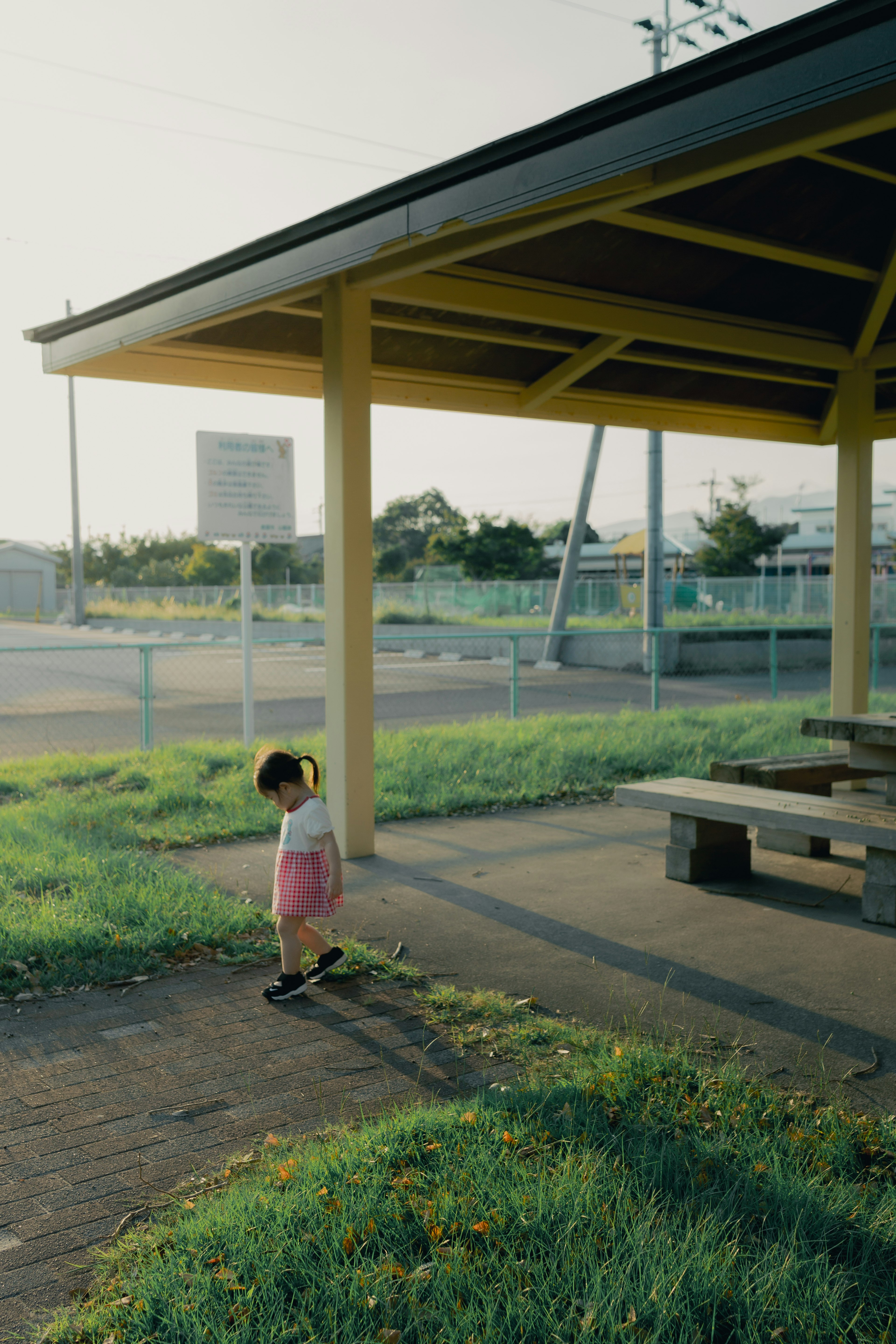 小さな子供がバス停の近くで歩いている風景