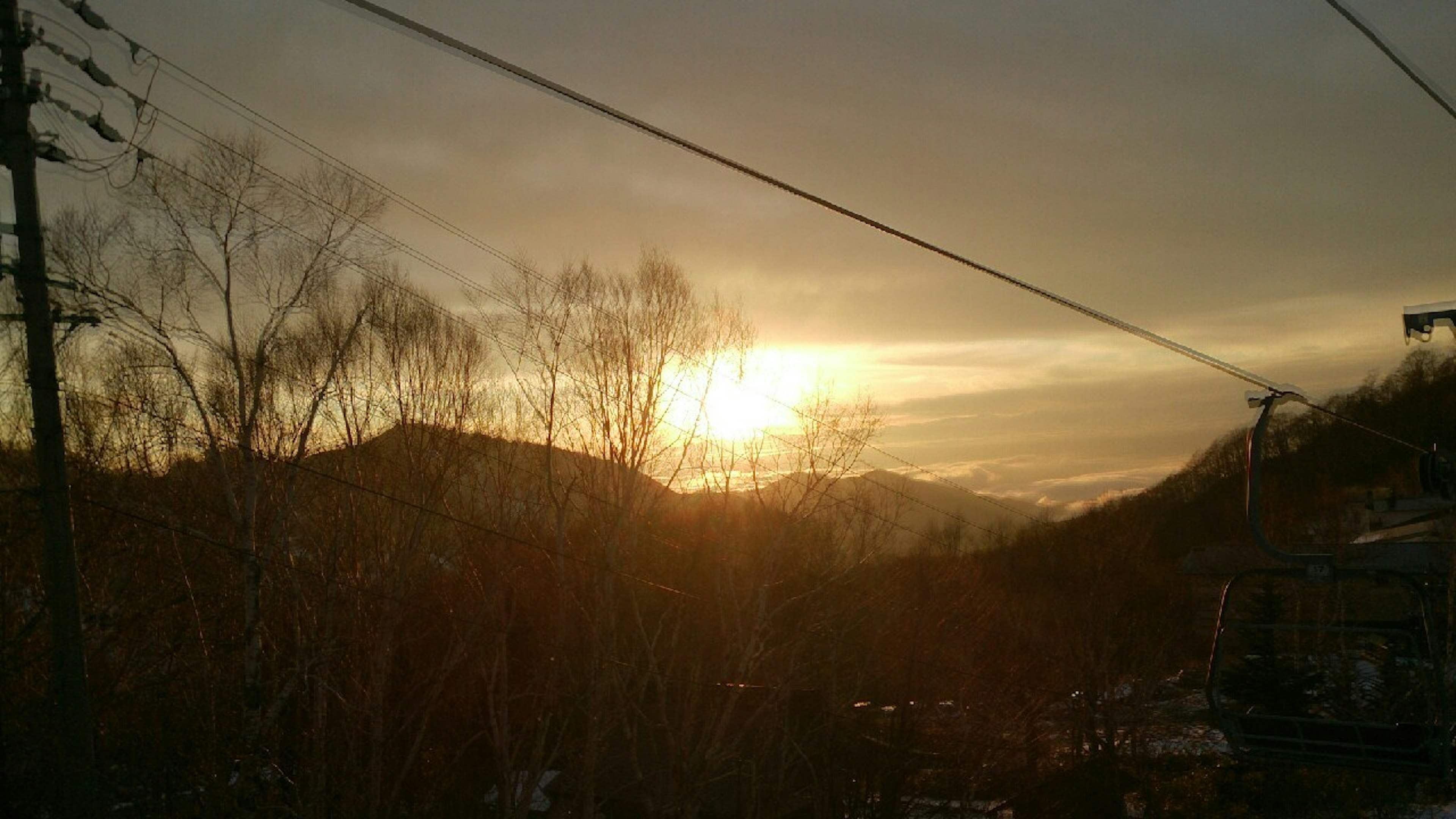 Lever de soleil sur les montagnes avec des poteaux électriques au premier plan