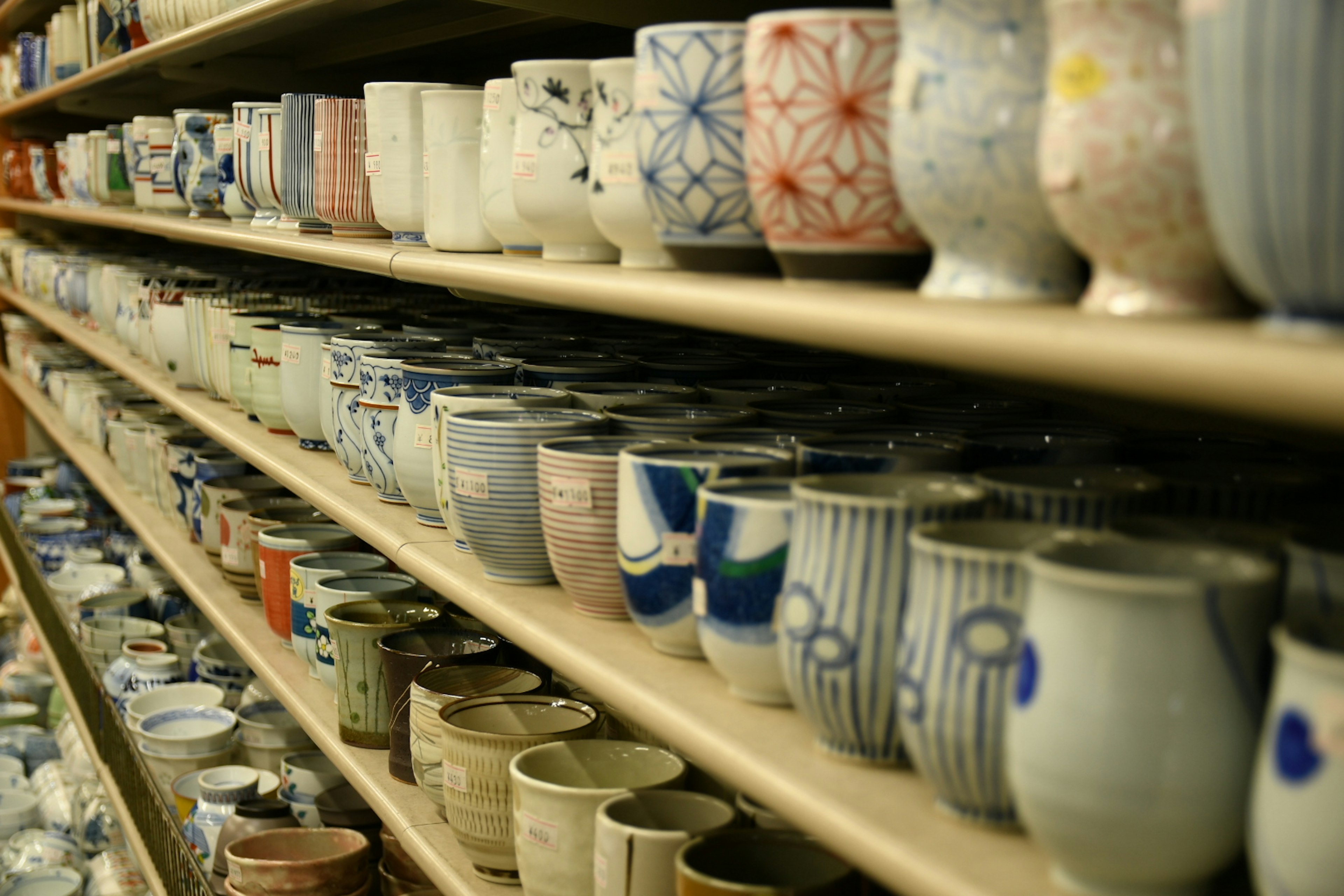 A variety of ceramic cups neatly arranged on shelves