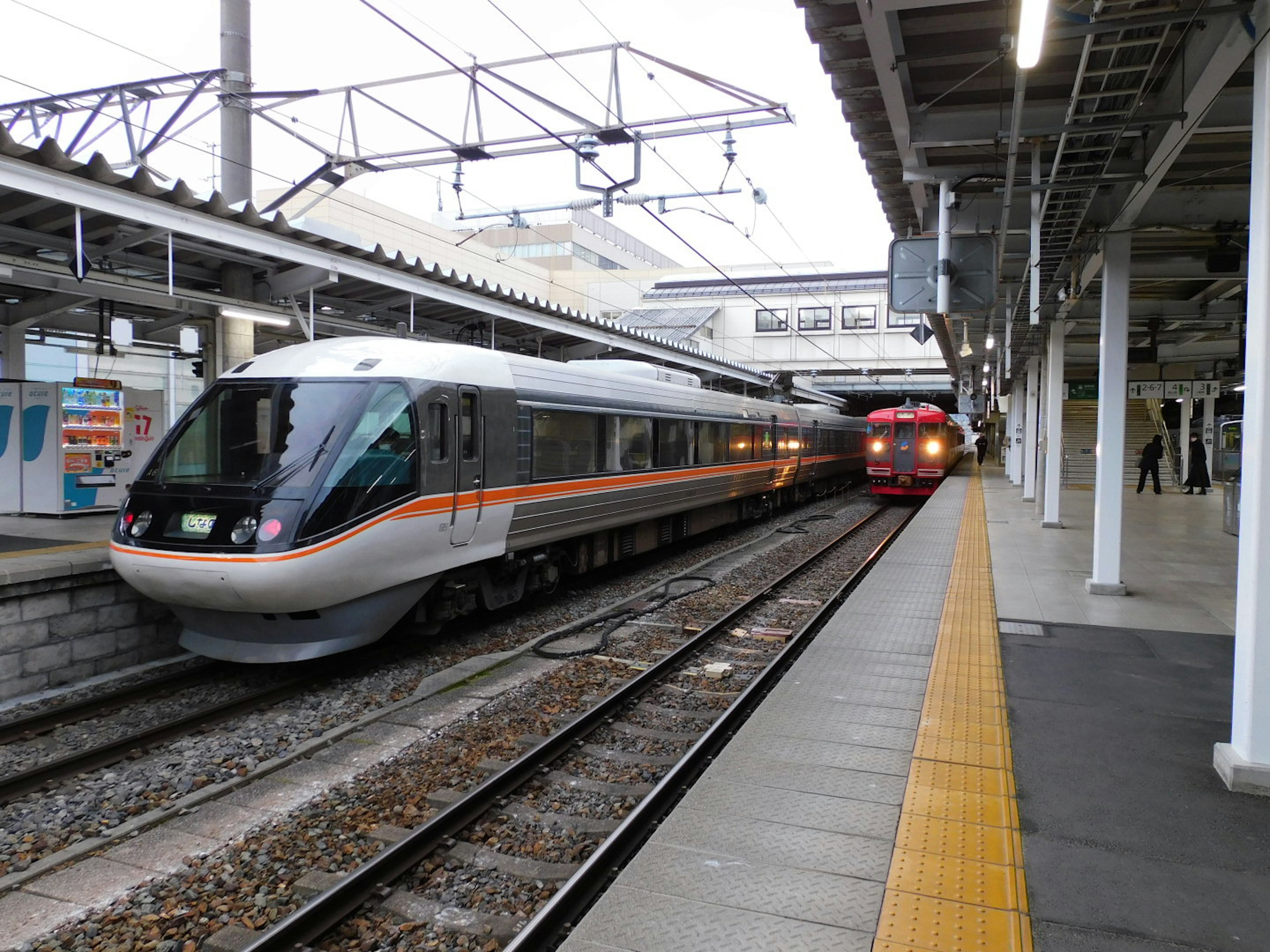 View of a train stopped at a station platform with another train passing by