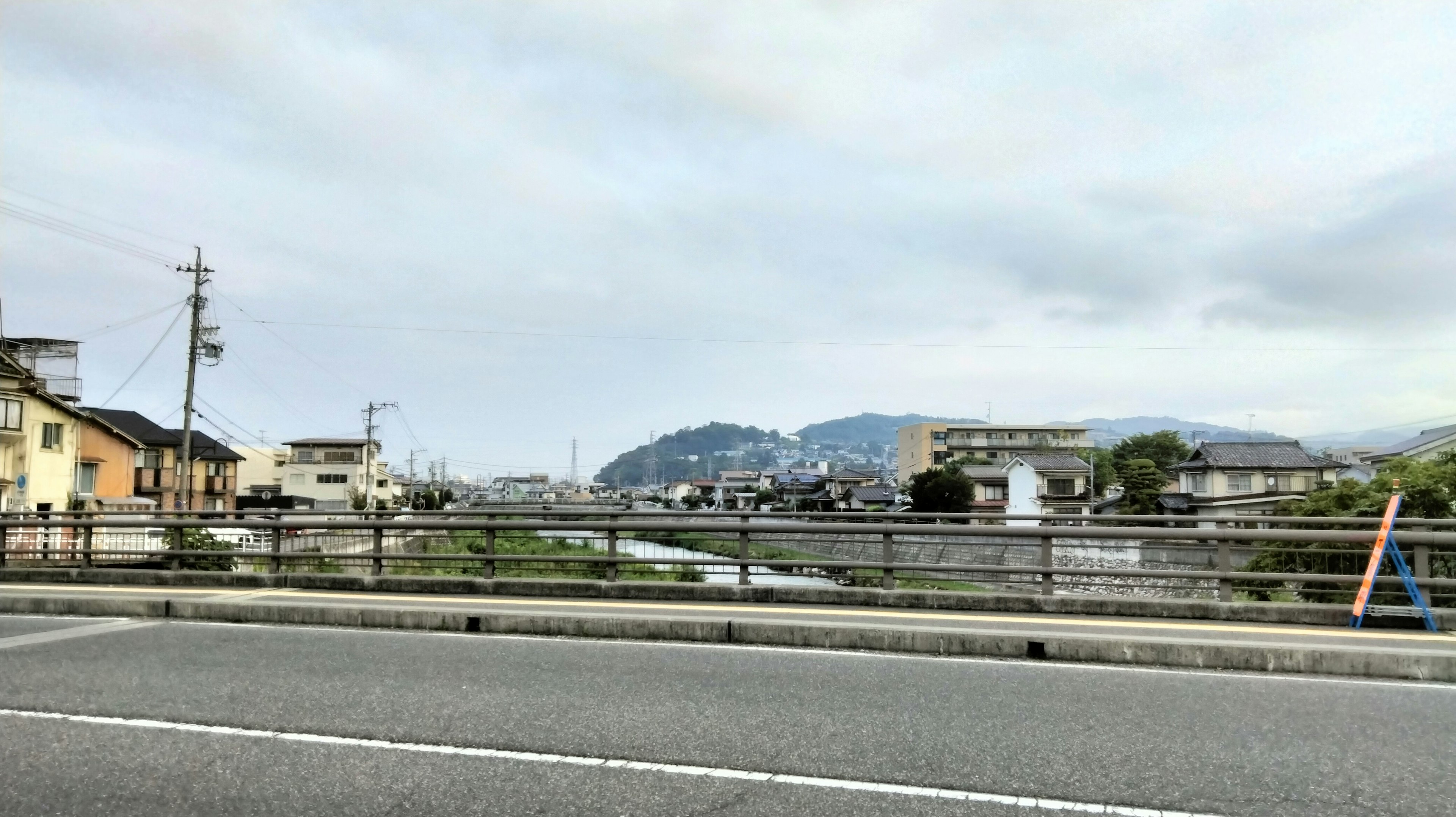 Paysage tranquille d'une ville au bord de la rivière avec des montagnes en arrière-plan