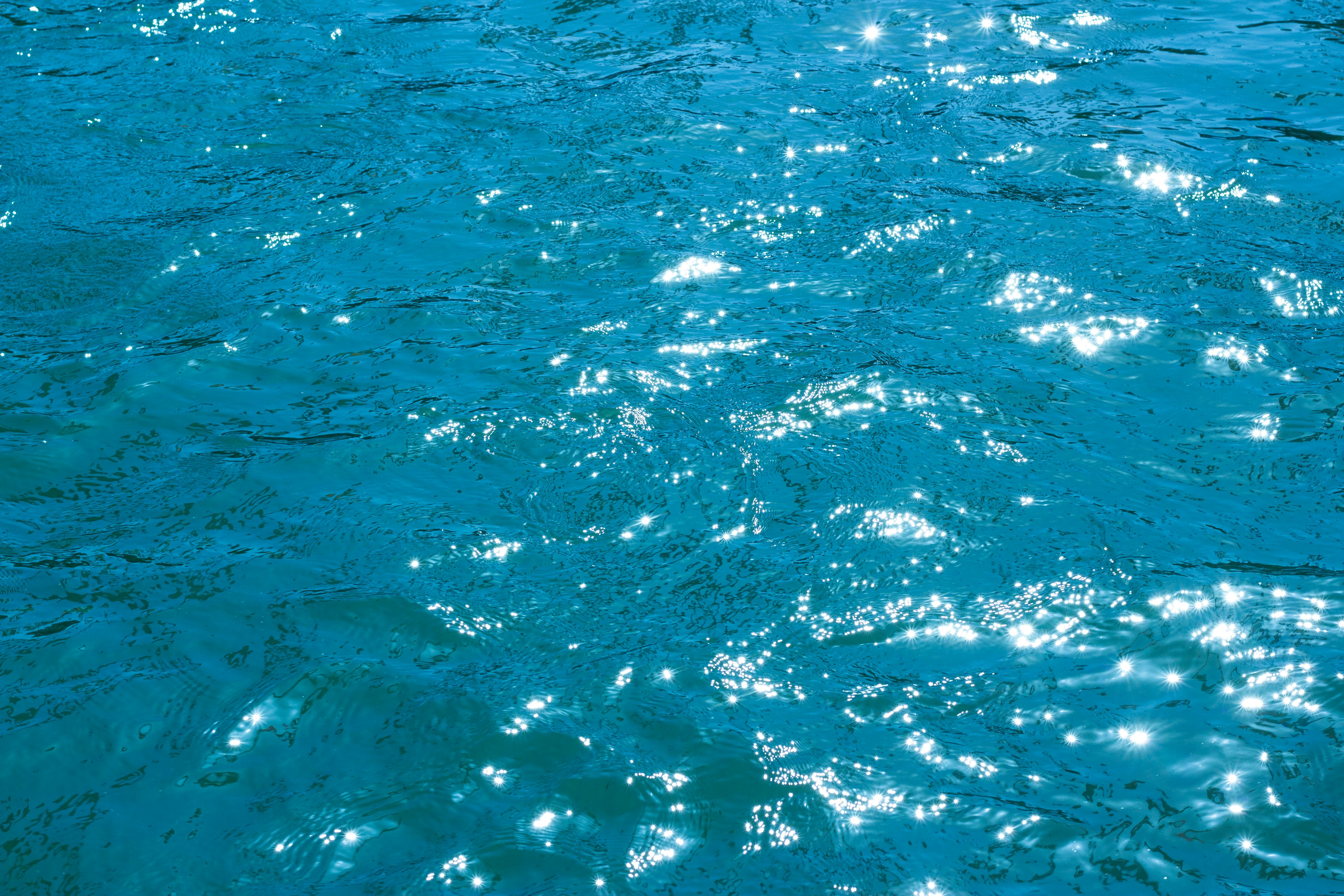 Glänzende blaue Wasseroberfläche, die Sonnenlicht reflektiert