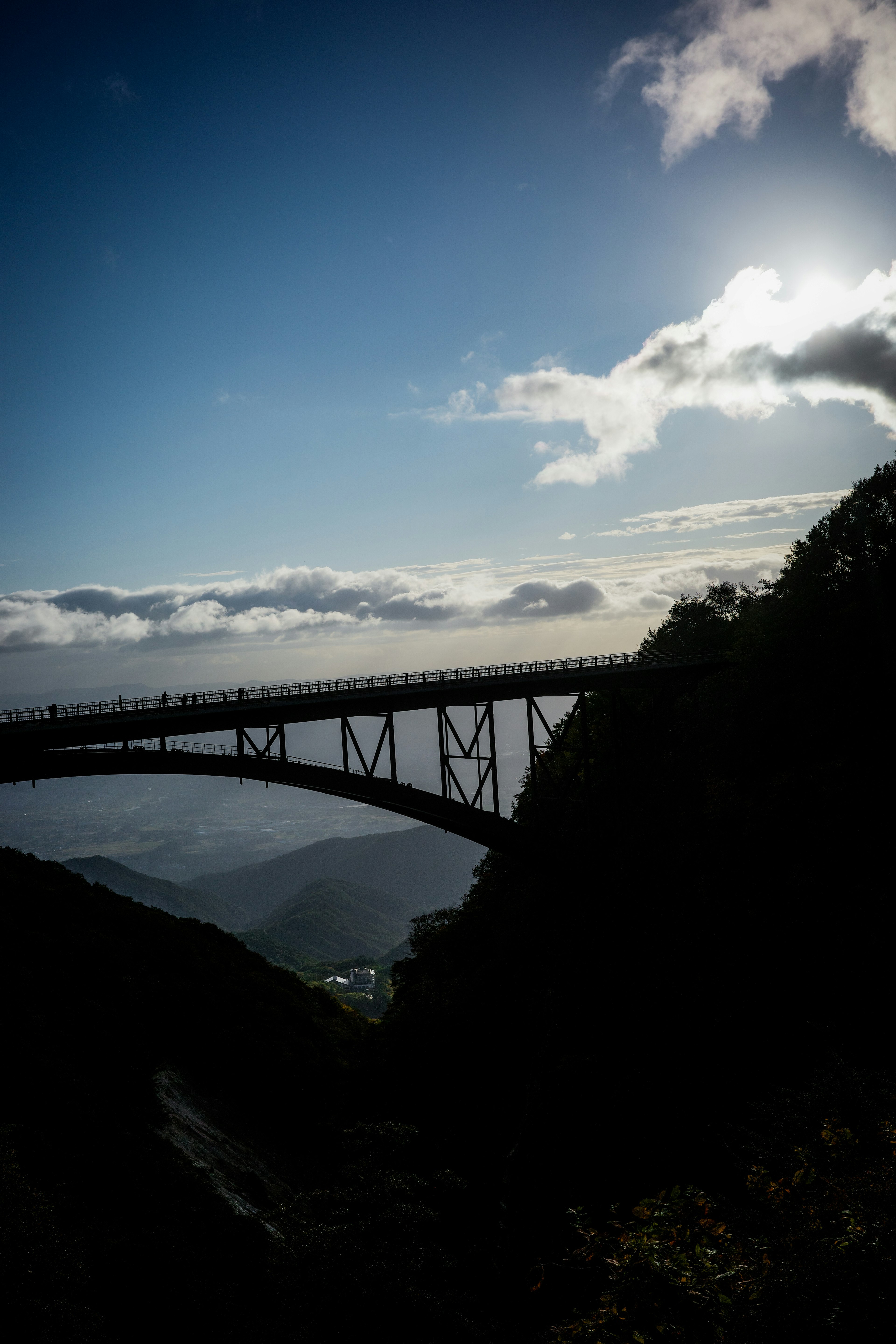 一座桥横跨在蓝天下的山地风景中