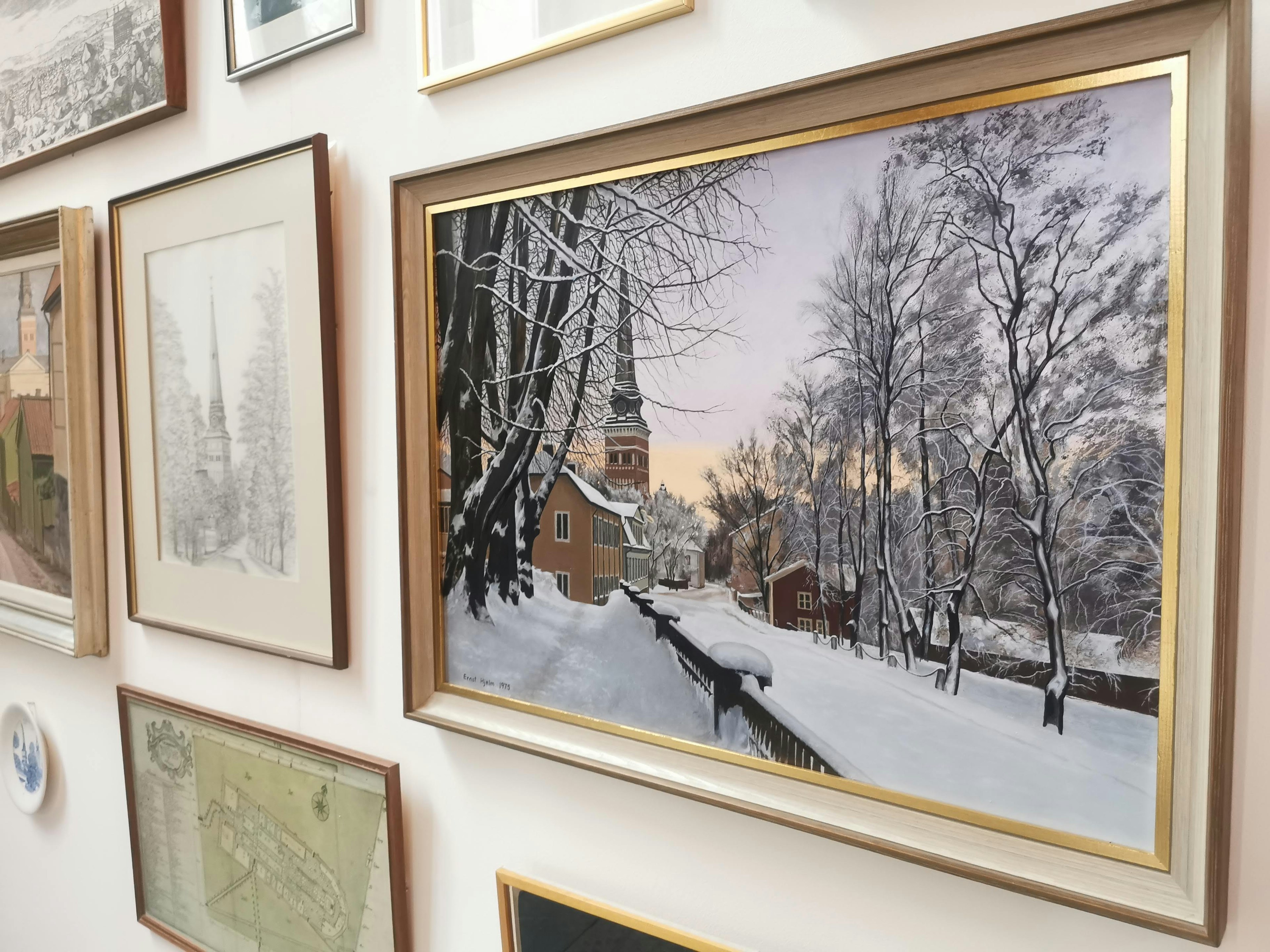 Eingefasstes Kunstwerk einer verschneiten Landschaft mit einer Kirche und Bäumen