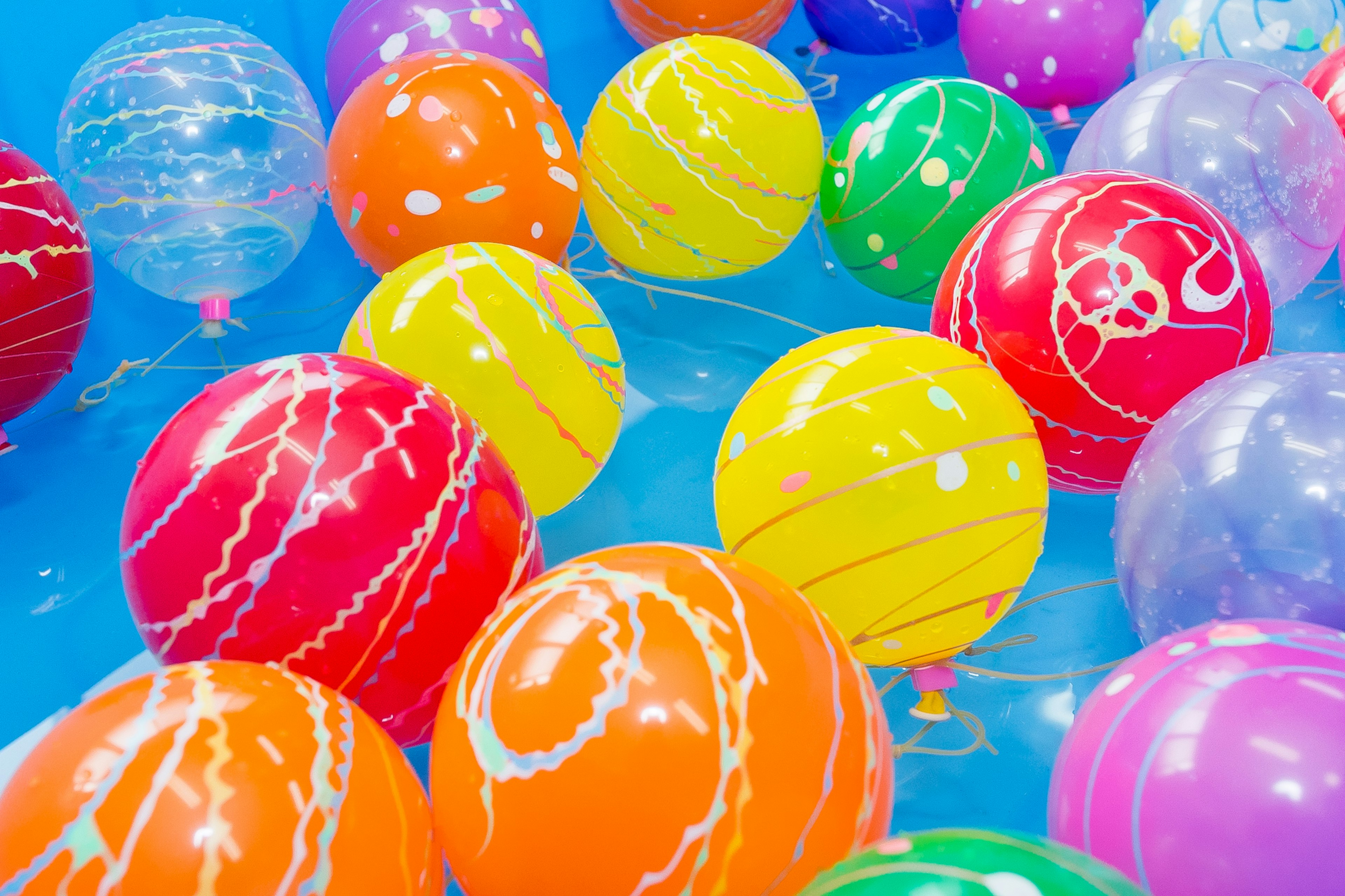 Des ballons colorés flottant sur une surface bleue