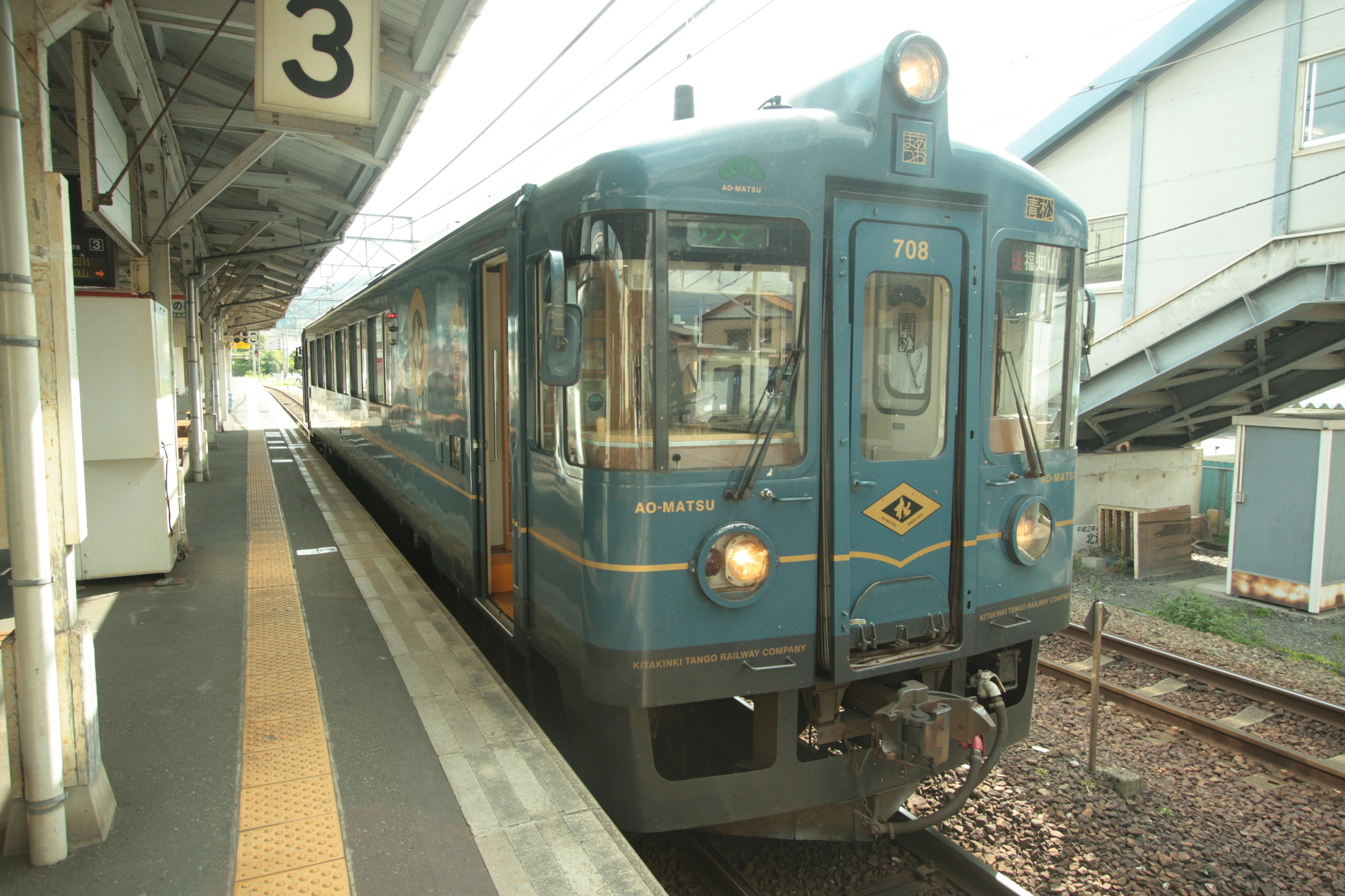 青い列車が駅のプラットフォームに停車中