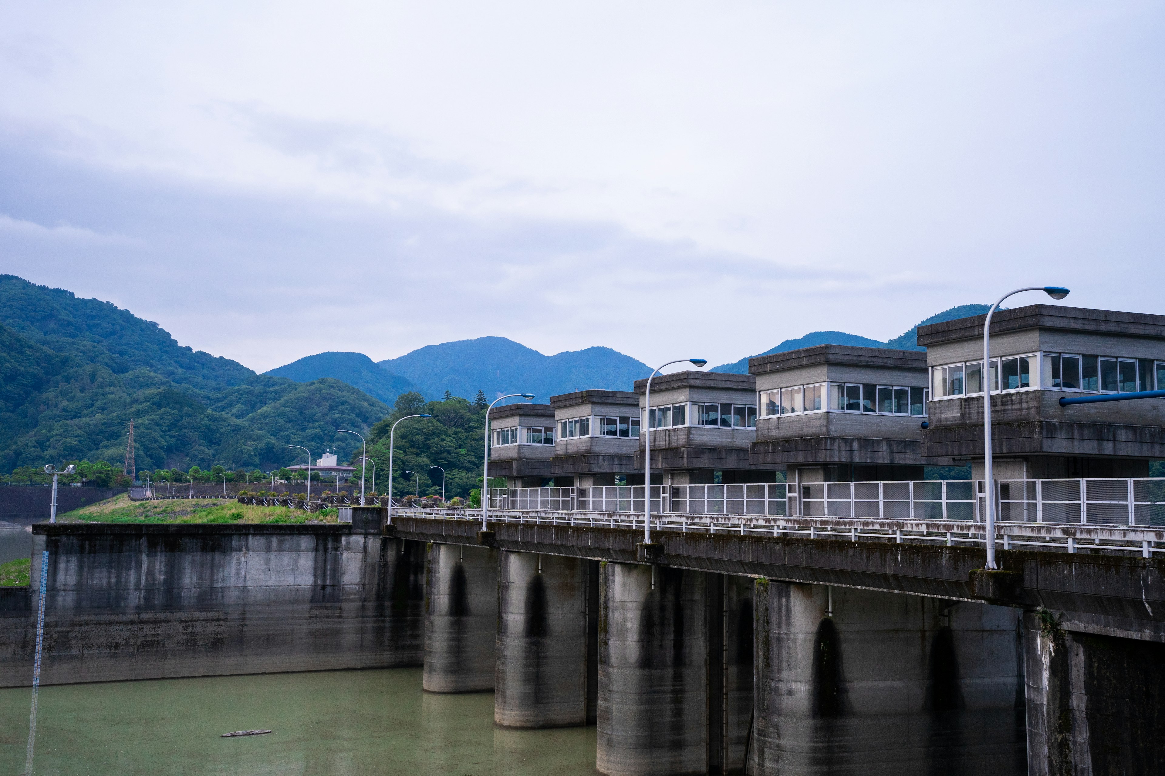 沿河的水壩結構和背景中的山脈的風景