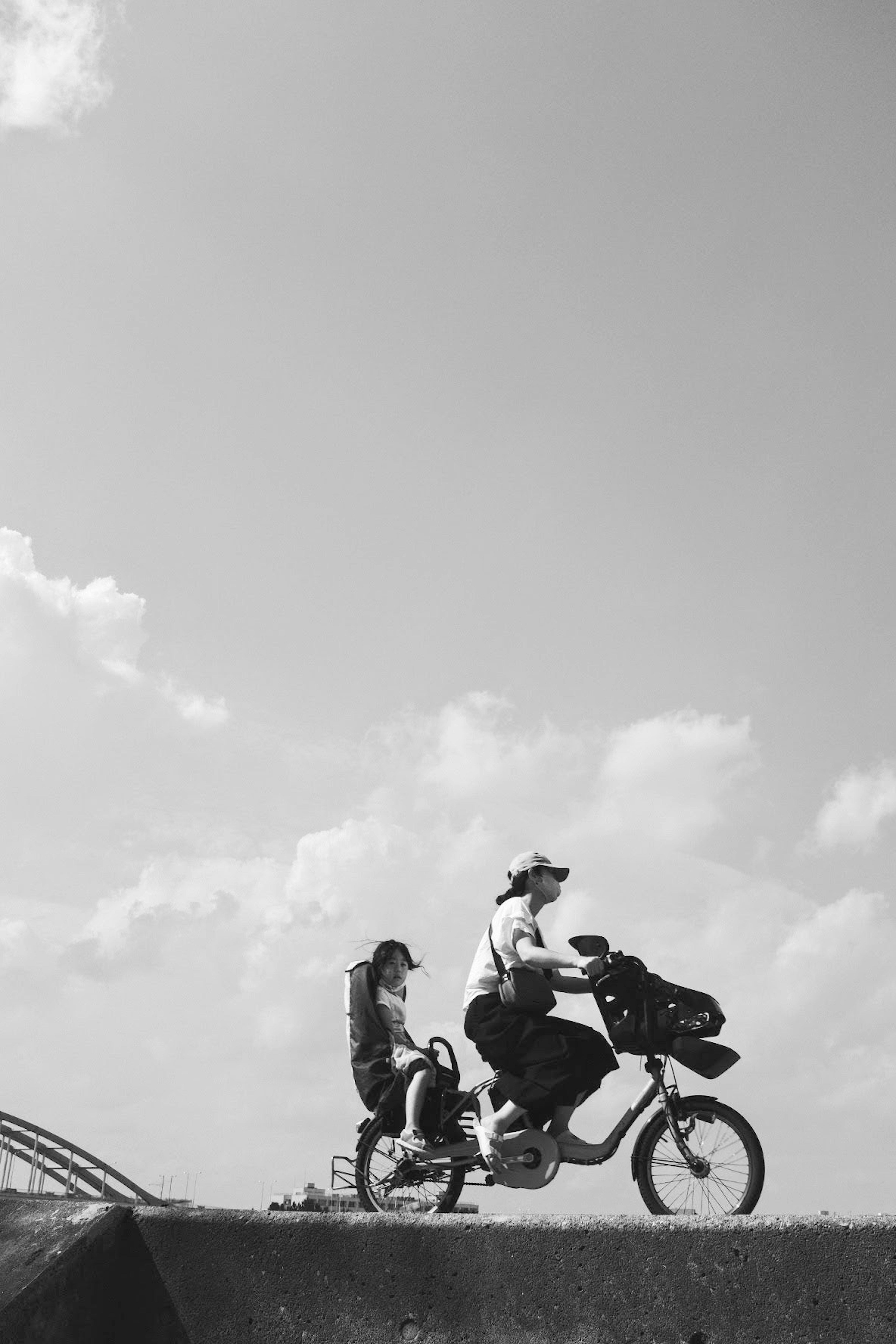 自転車に乗る親子の白黒写真青空と雲