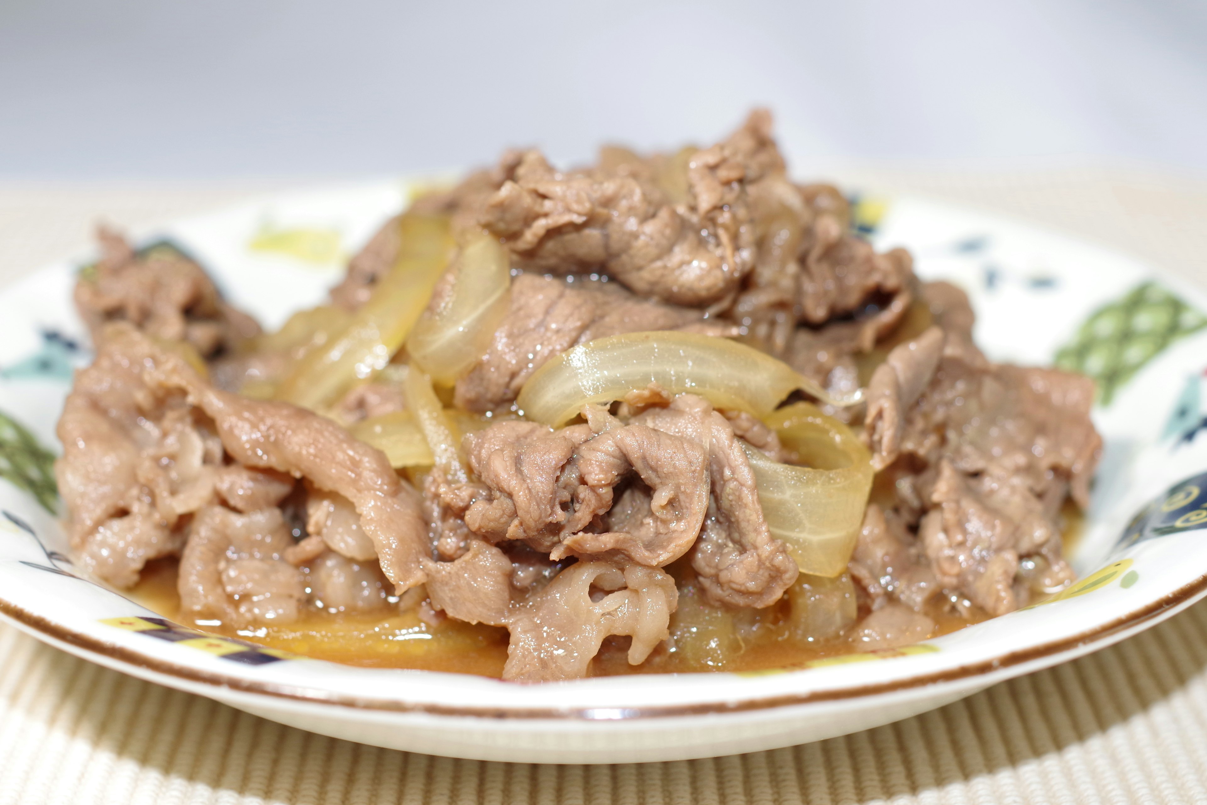 Carne de res en rodajas y cebollas salteadas servidas en un plato