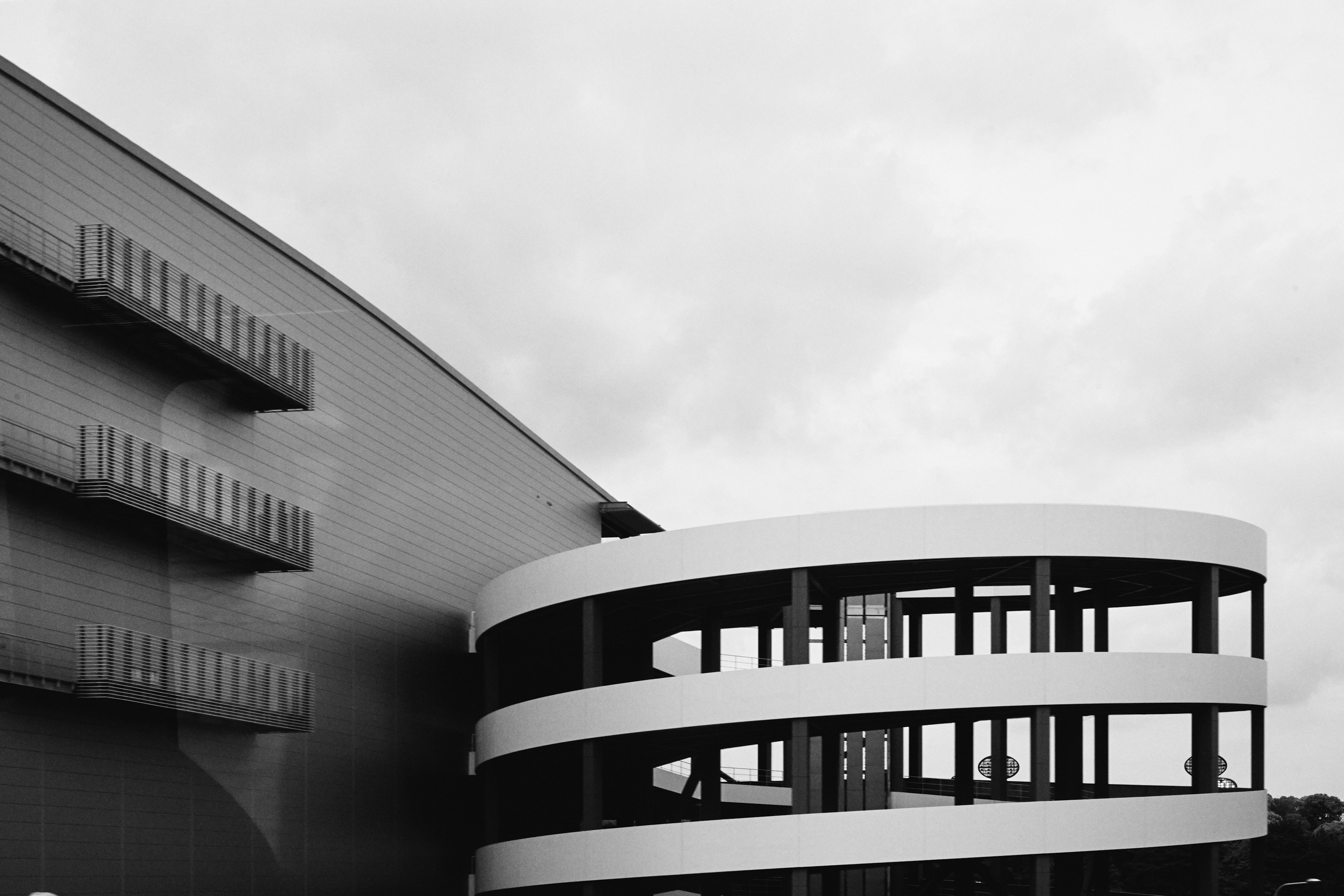 Extérieur d'un bâtiment moderne avec un design courbé et une palette monochrome