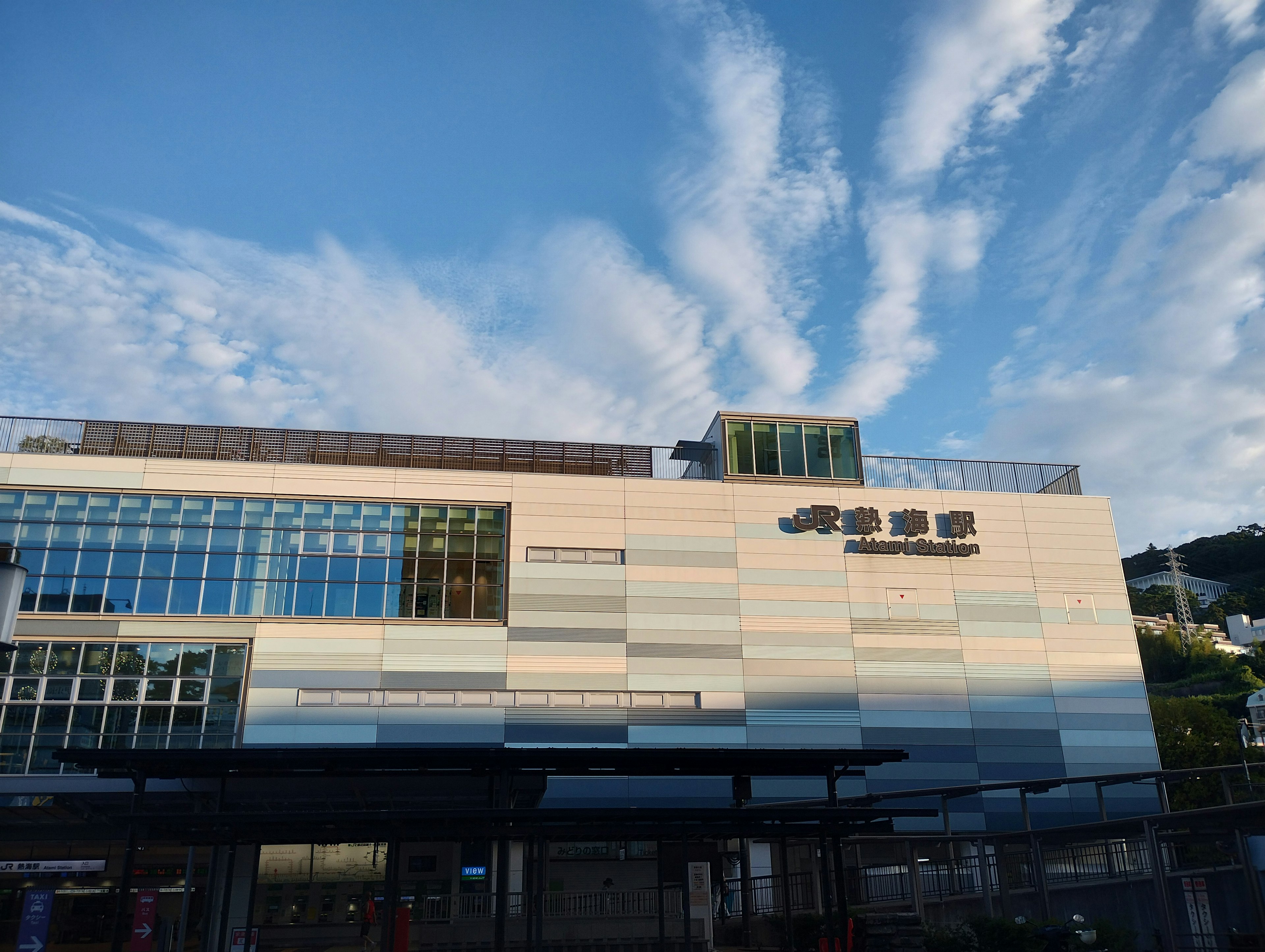 Façade d'un bâtiment moderne sous un ciel bleu avec de nombreuses fenêtres en verre et de beaux motifs de couleur