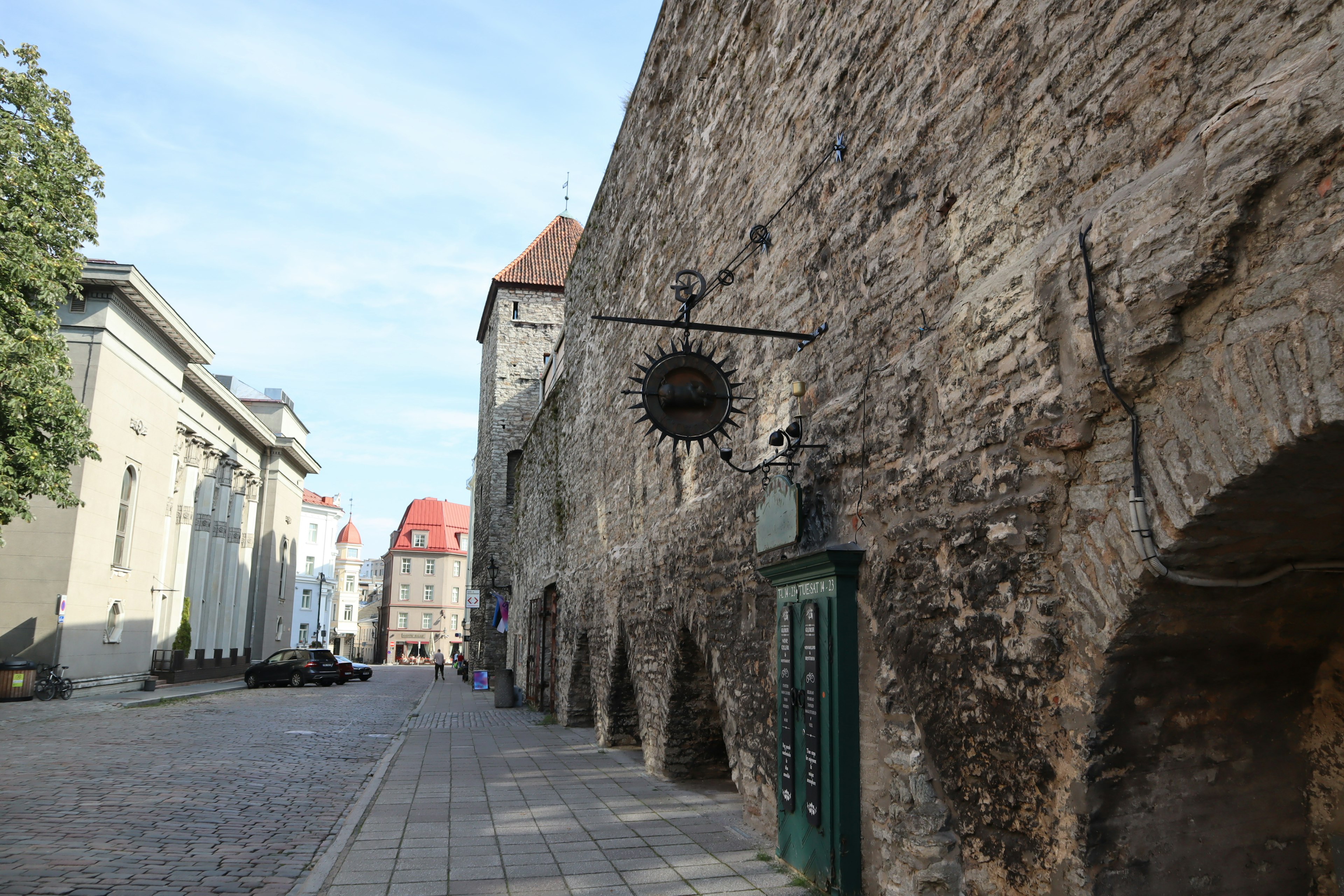 Vista de la calle con un viejo muro de piedra y edificios históricos