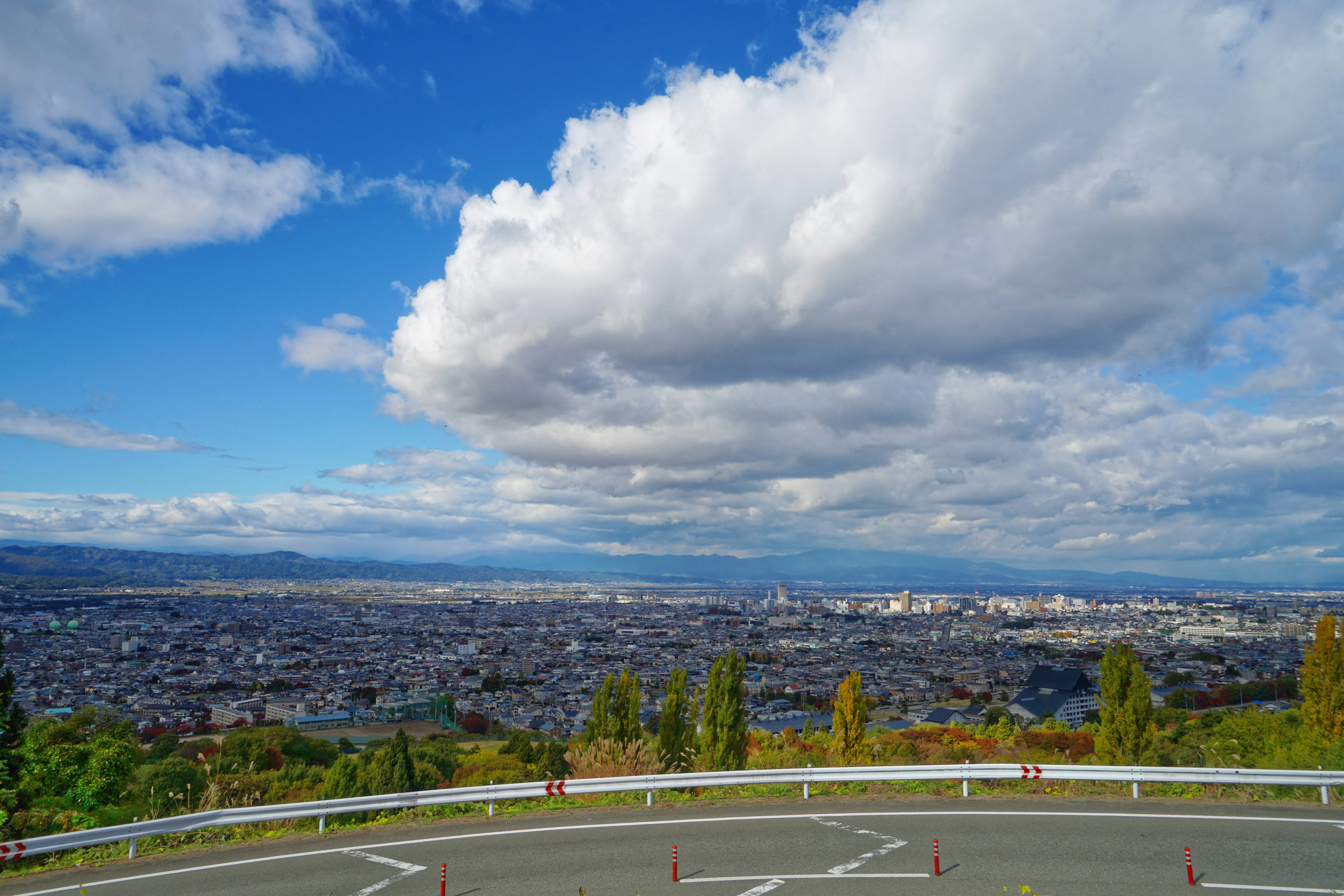 Panoramic view of a city under a blue sky with white clouds