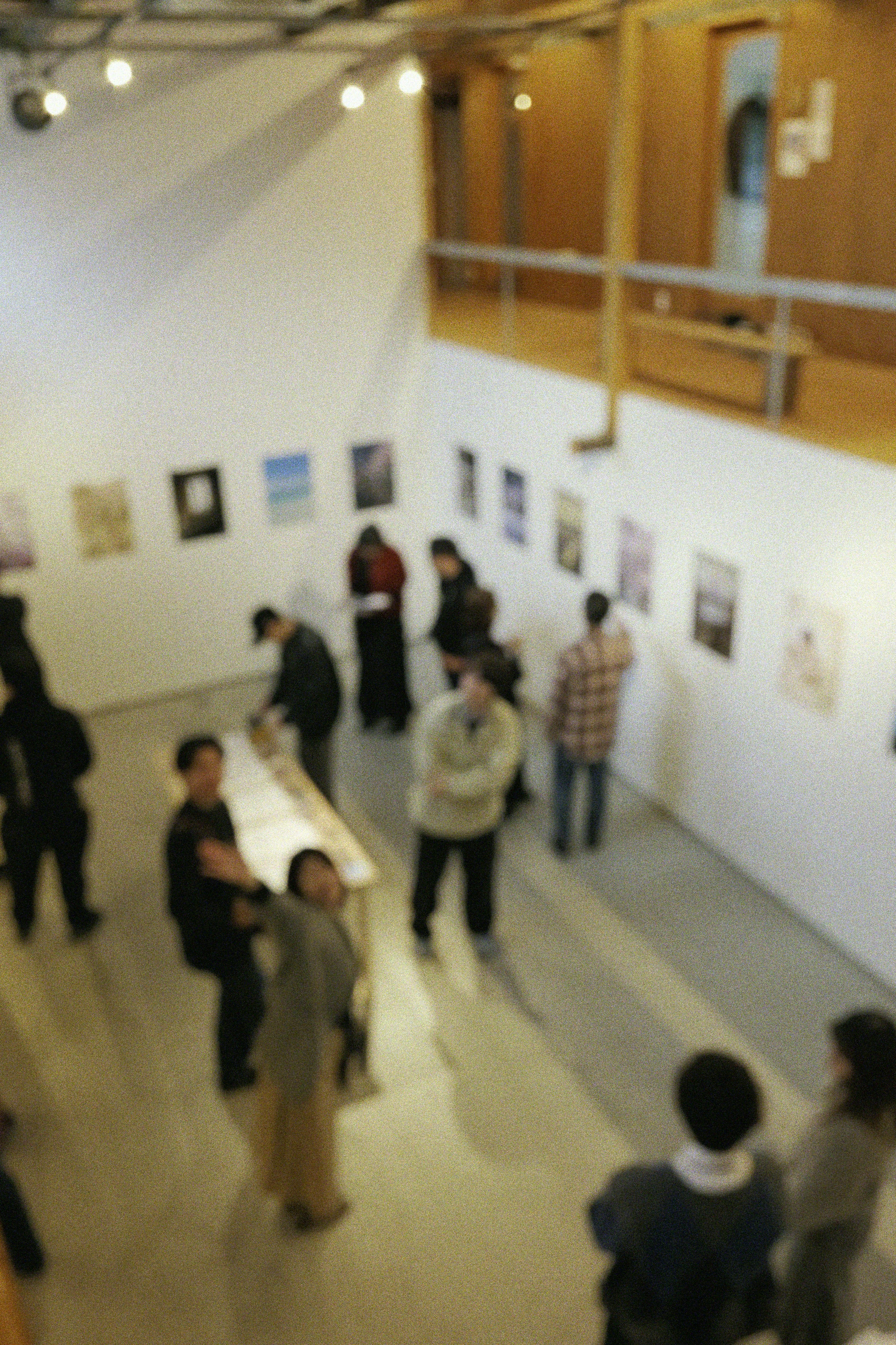 View of an art gallery exhibition with visitors admiring artworks