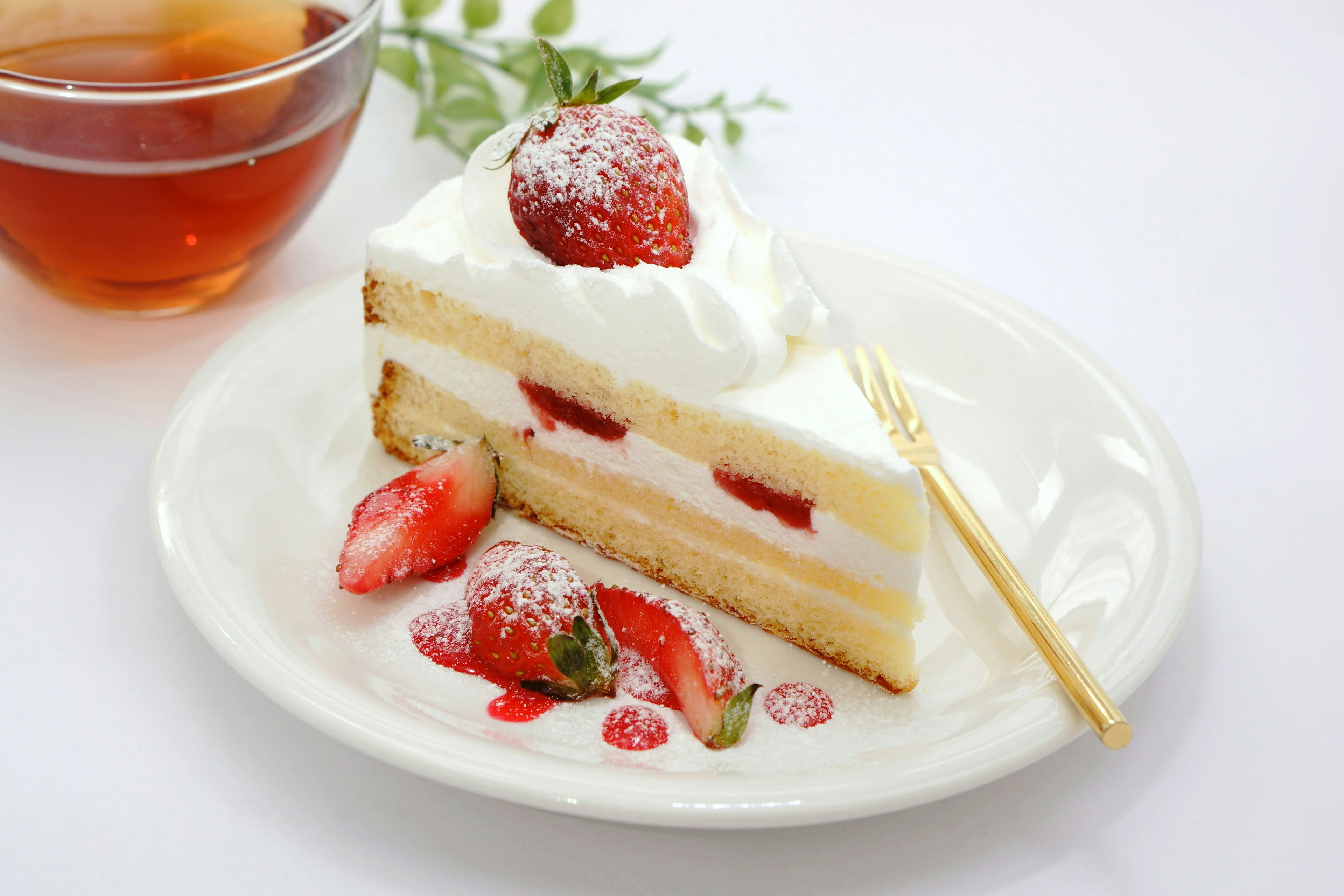 Pastel de capas cubierto con crema y fresas servido con té