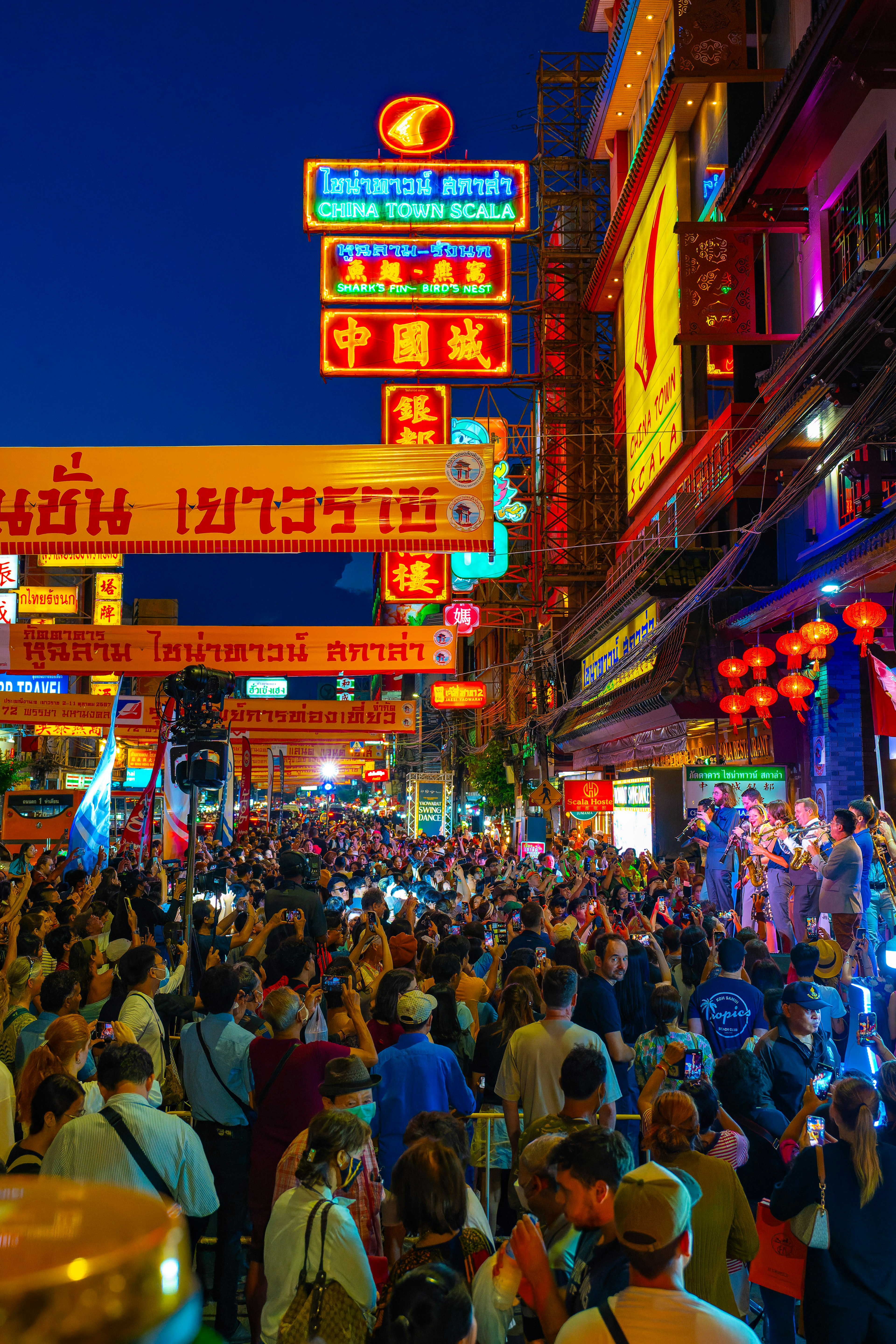 Calle bulliciosa de Chinatown por la noche llena de multitudes y letreros de neón coloridos