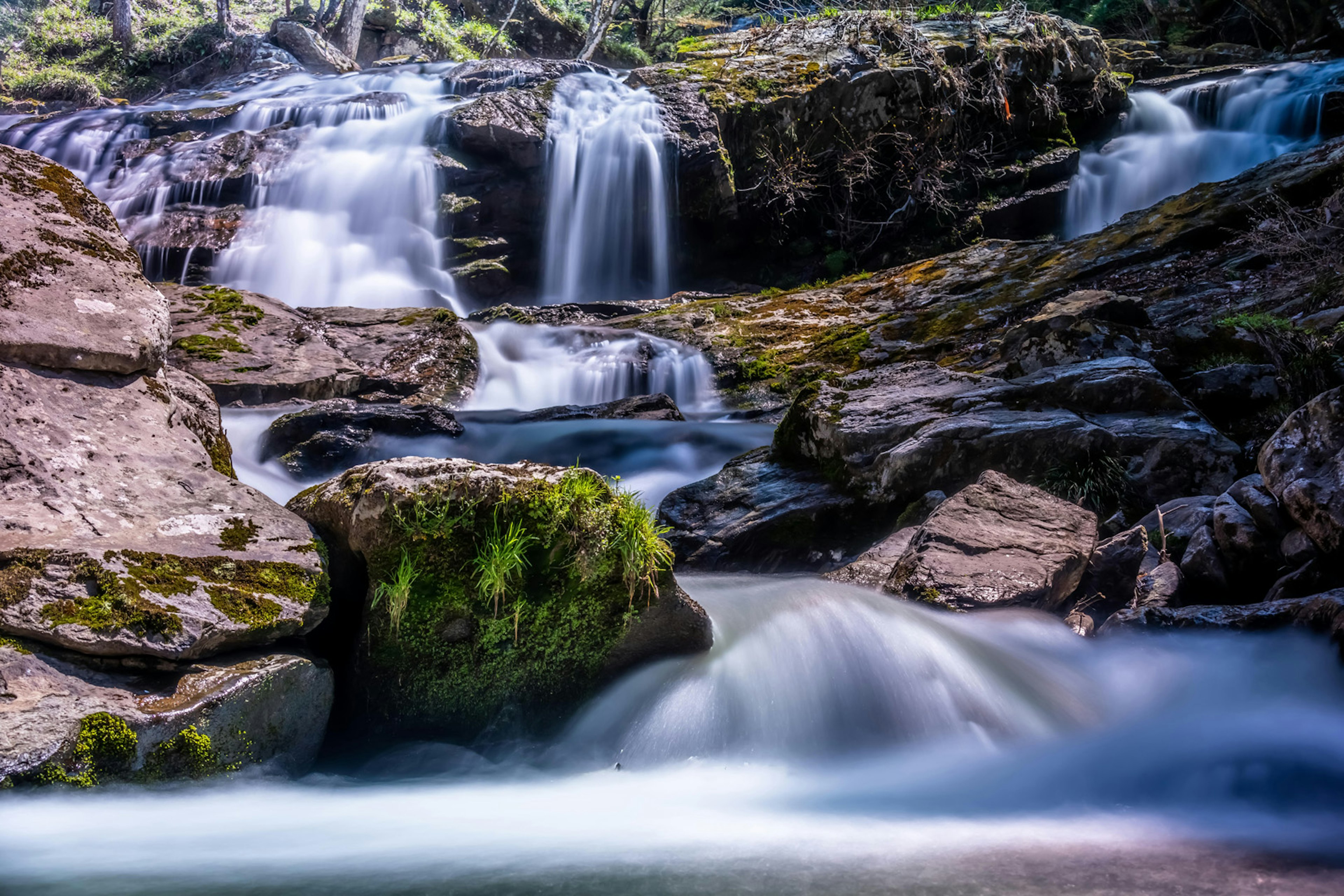 Malersicher Wasserfall mit fließendem Wasser und moosbedeckten Felsen