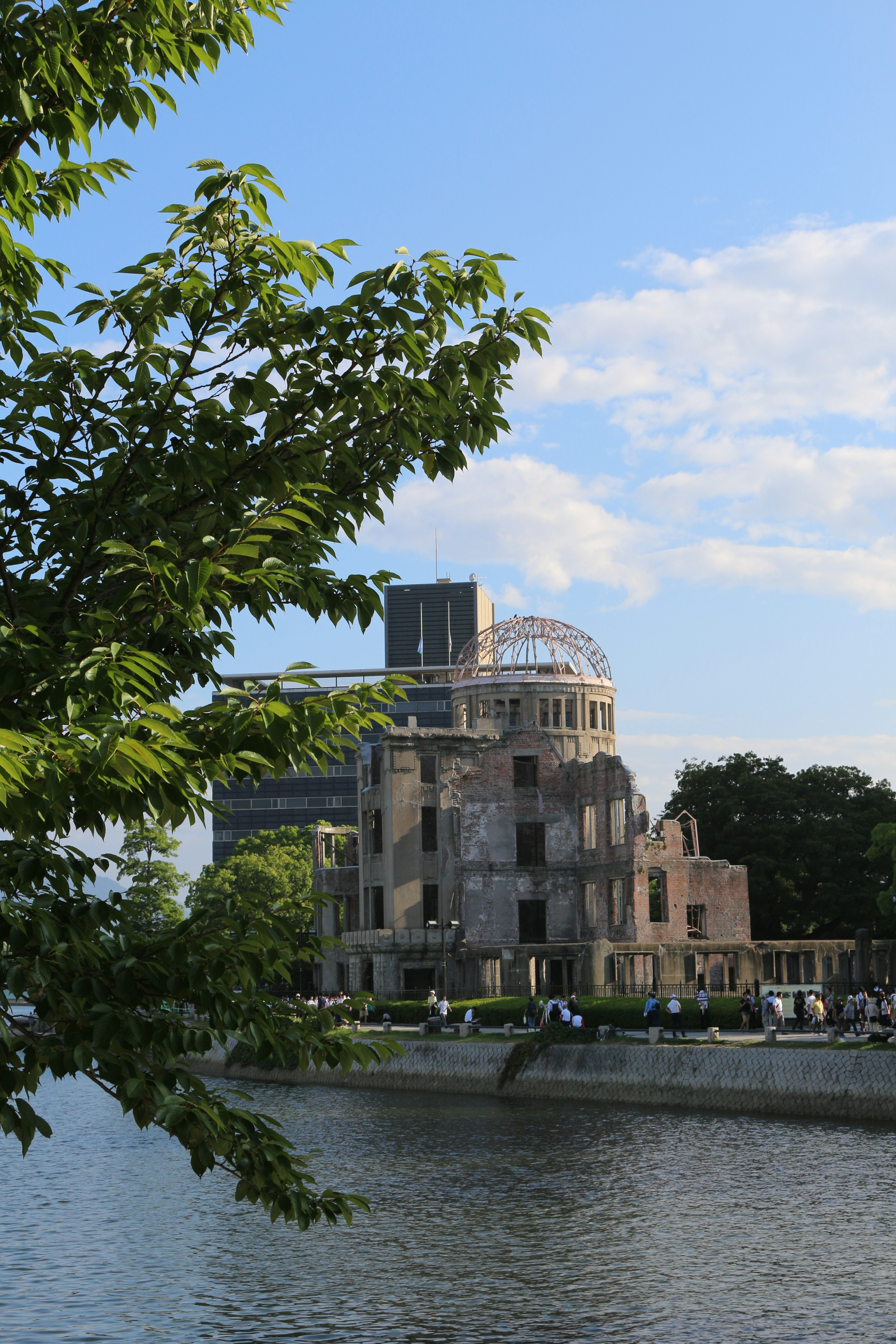 Kubah bom atom di Hiroshima di tepi sungai dengan vegetasi subur