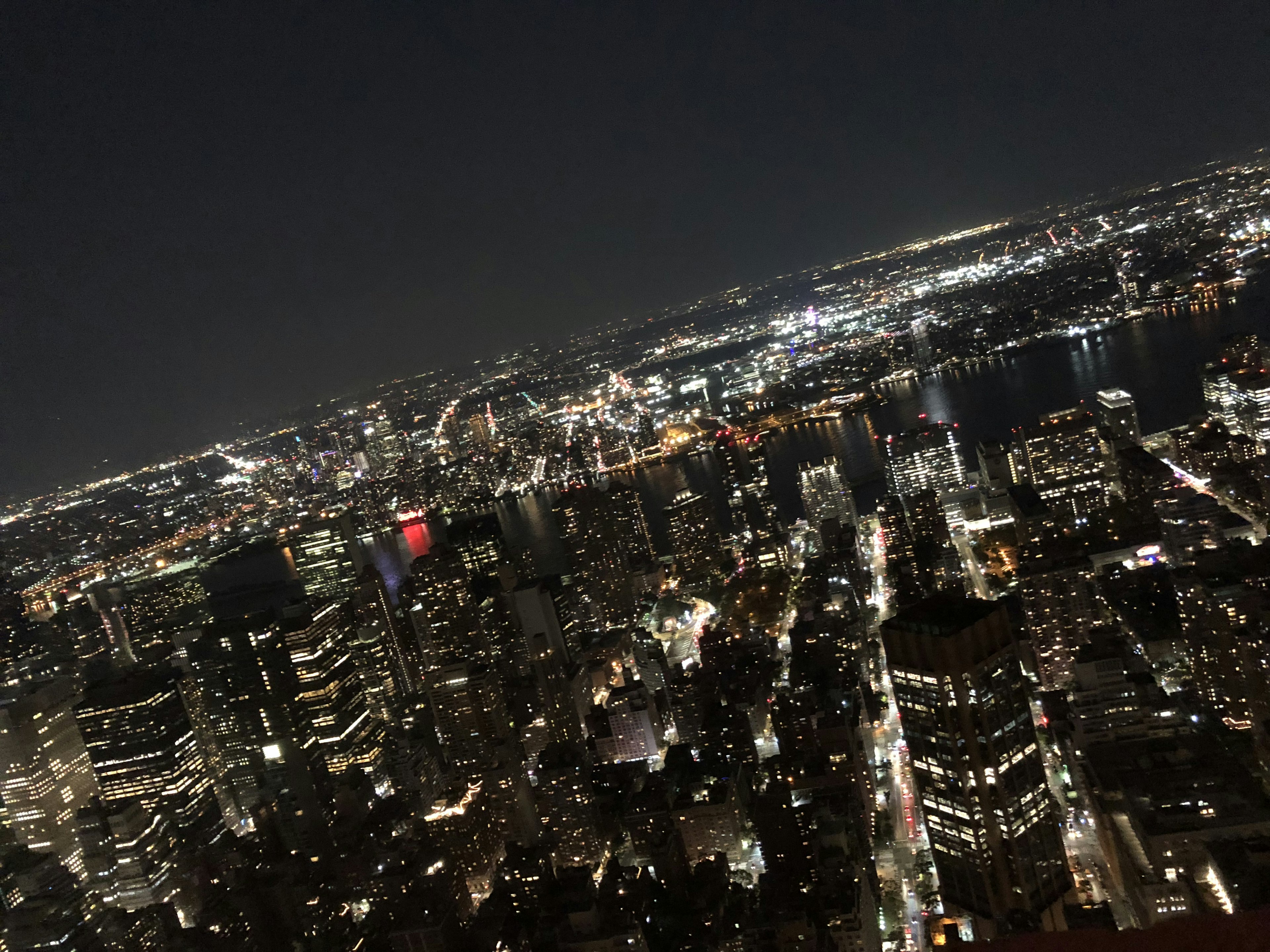 Aerial view of a city skyline at night illuminated by numerous lights