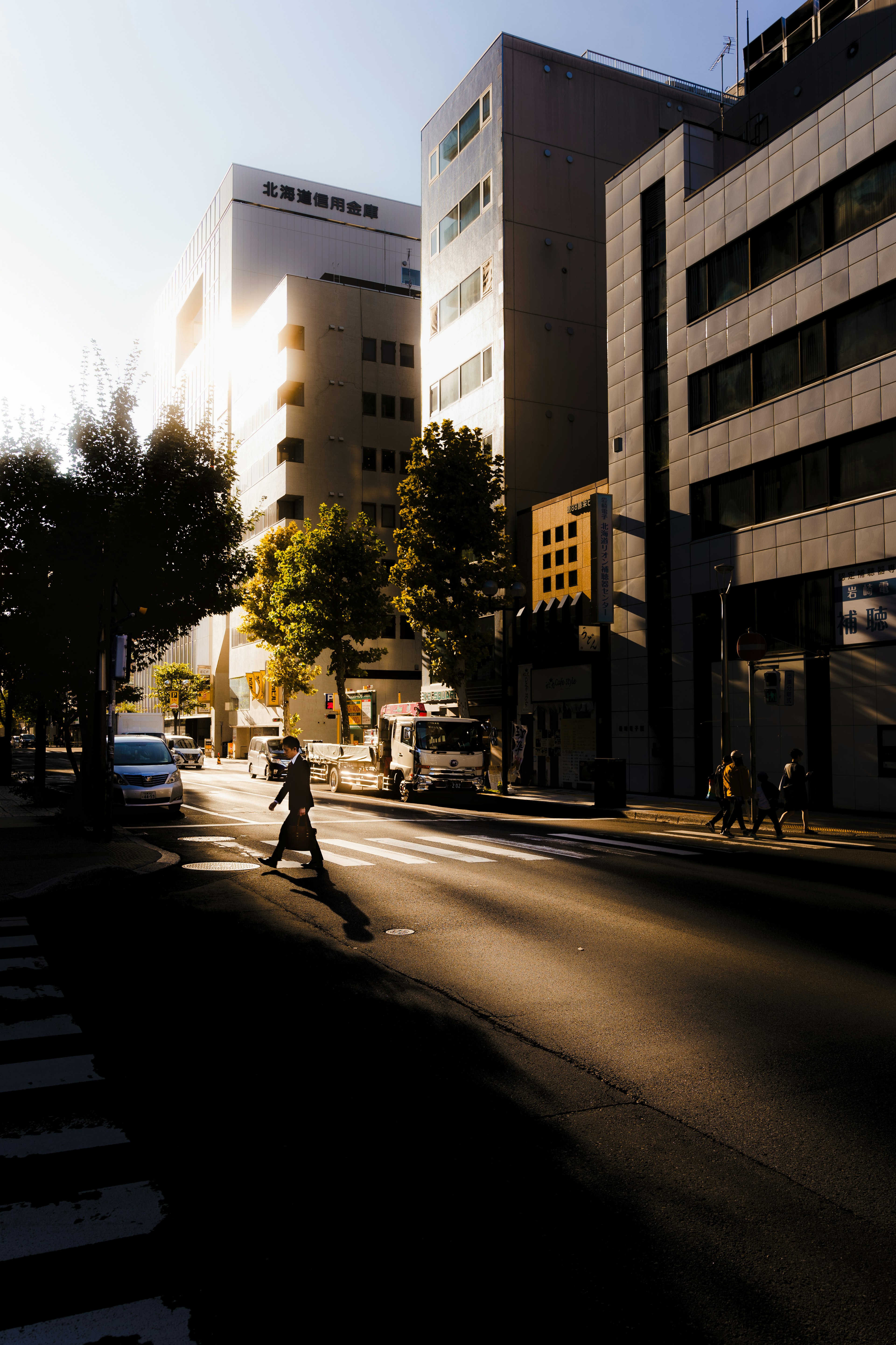 Evening scene of a pedestrian crossing the street in an urban area