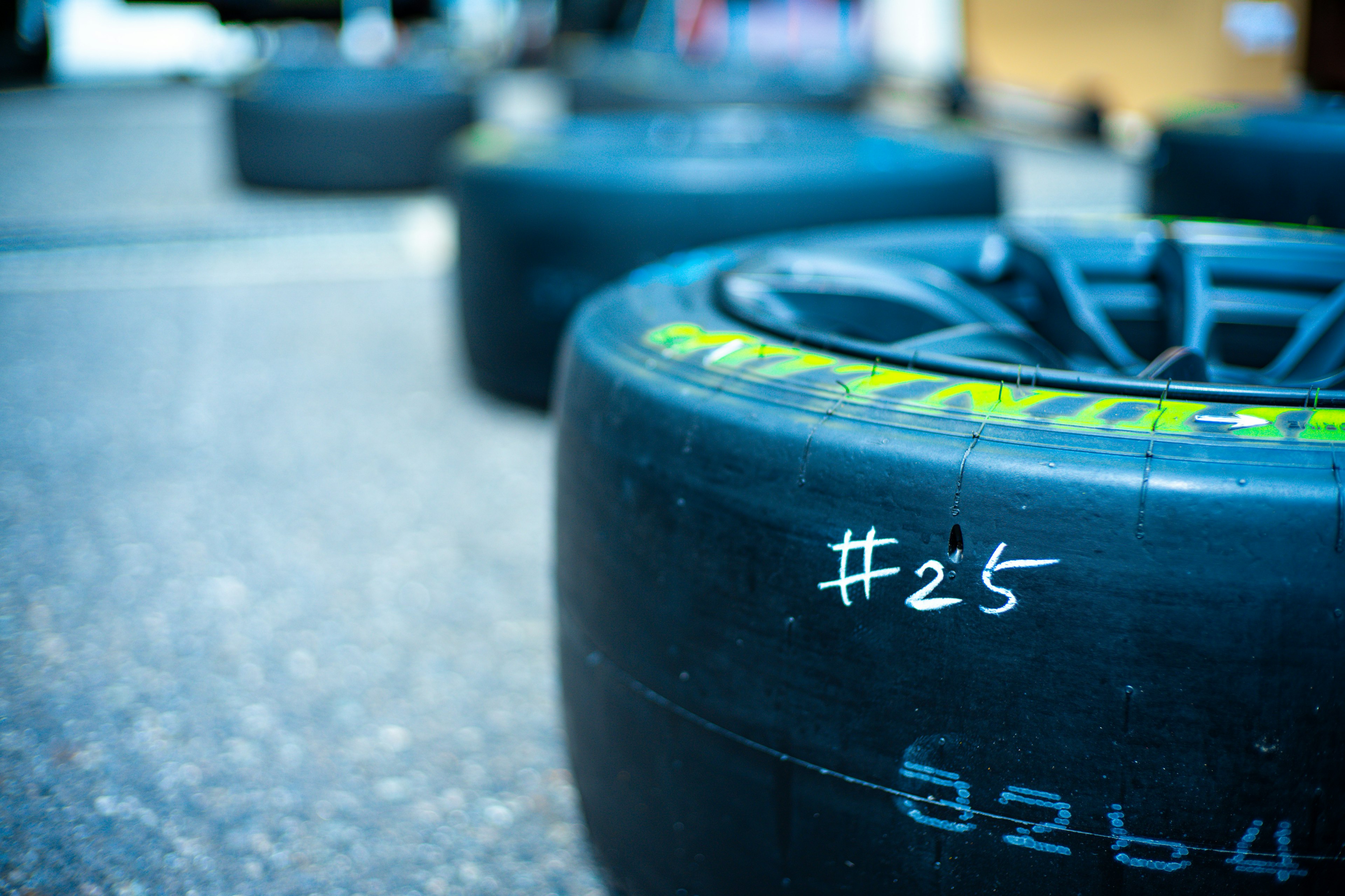 Image of racing tires lined up with the number #25 written in white on one tire