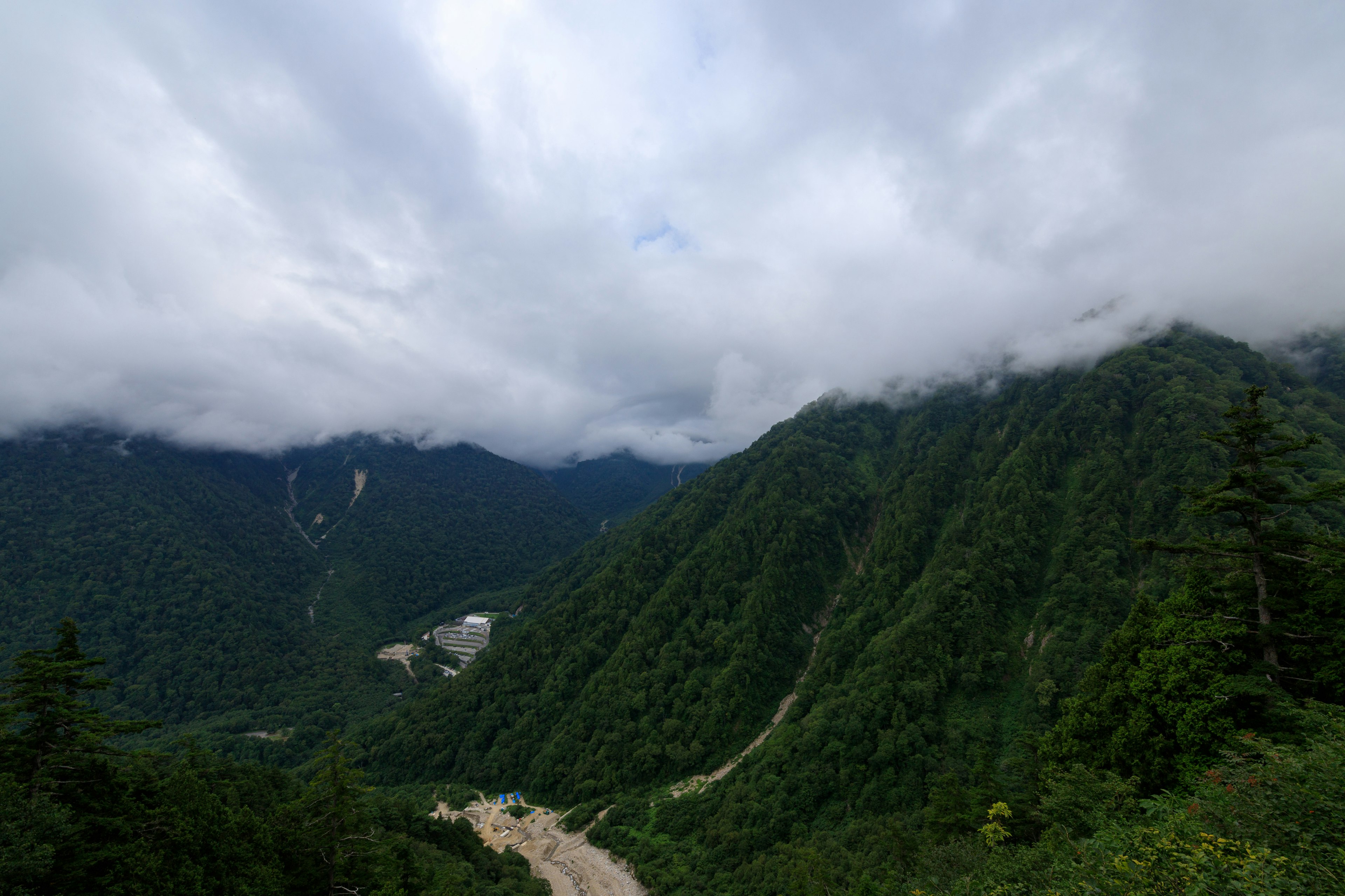 緑豊かな山々と雲に覆われた空の風景