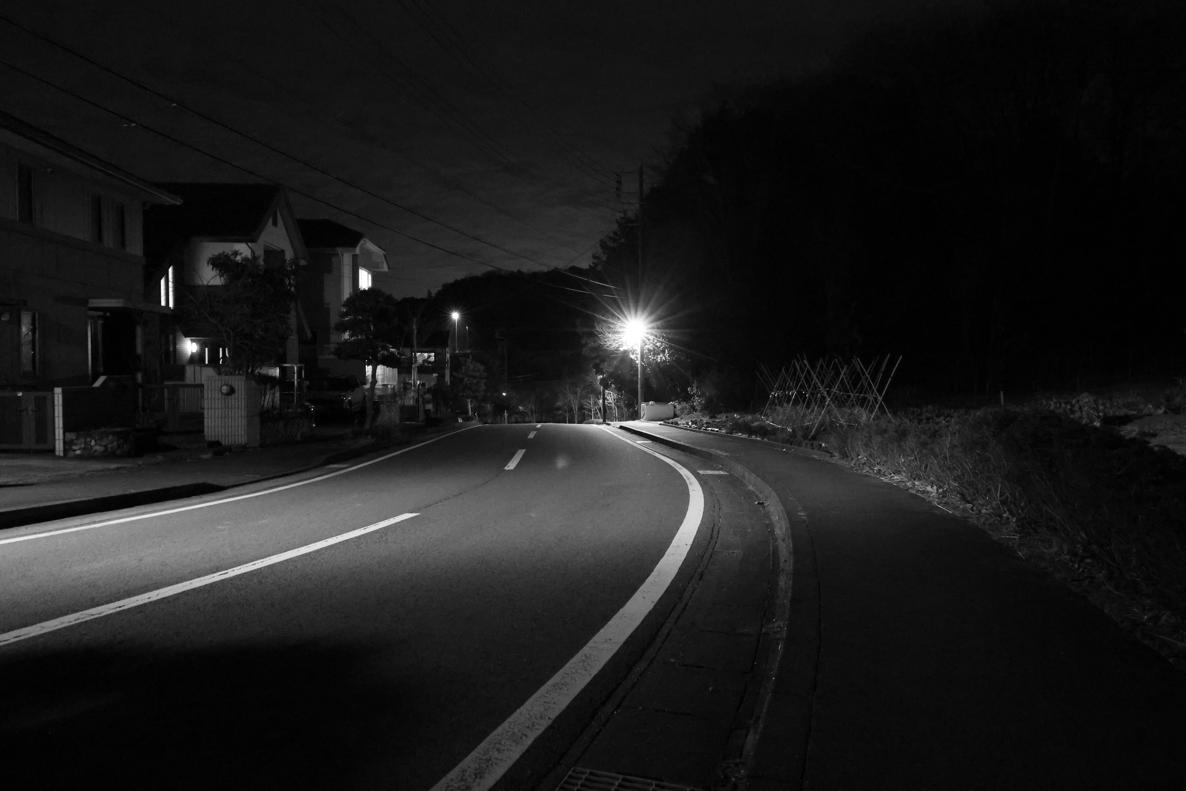 Jalan melengkung dalam pemandangan malam dengan penerangan jalan