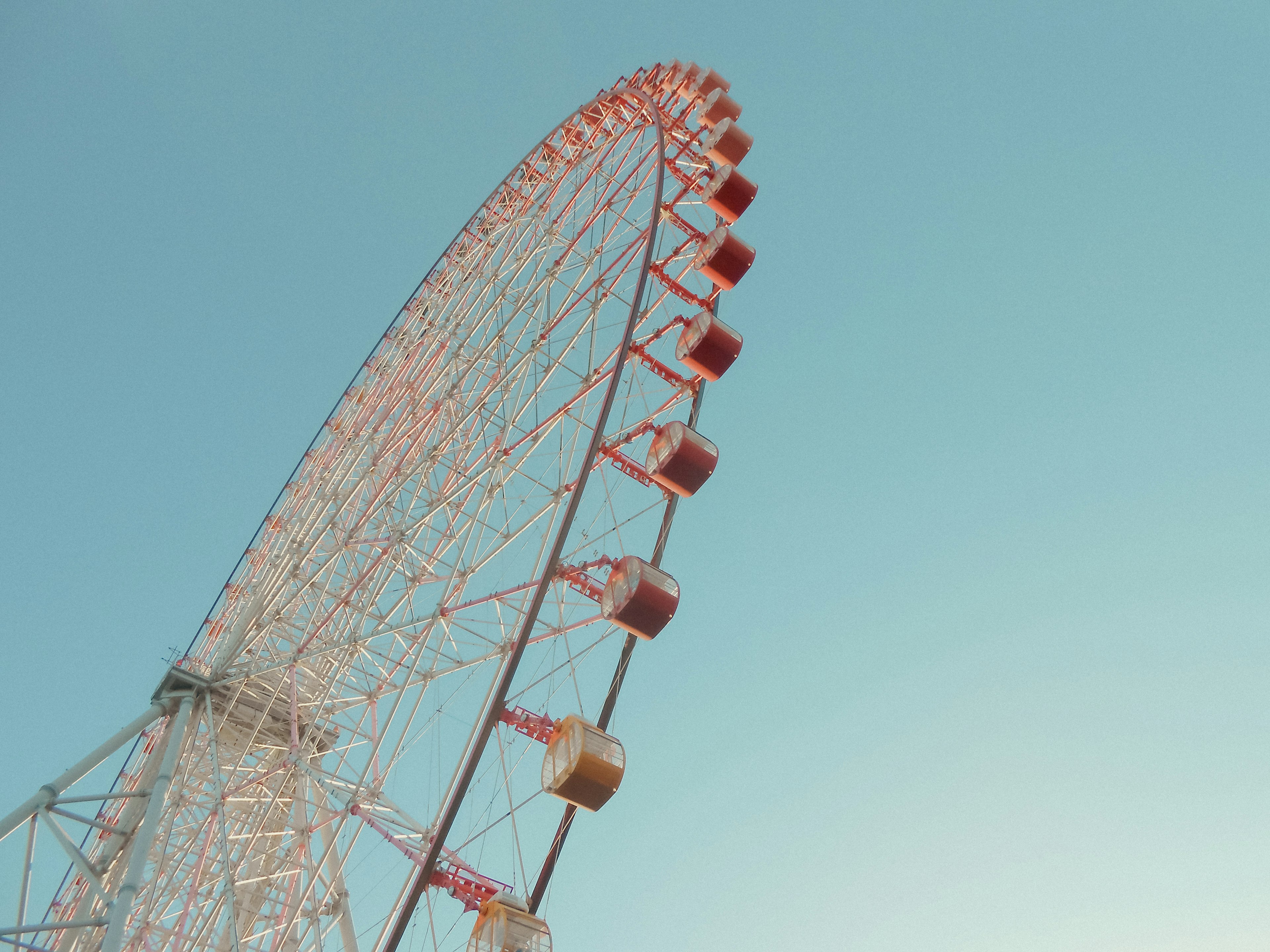 赤と白の観覧車が青空にそびえる