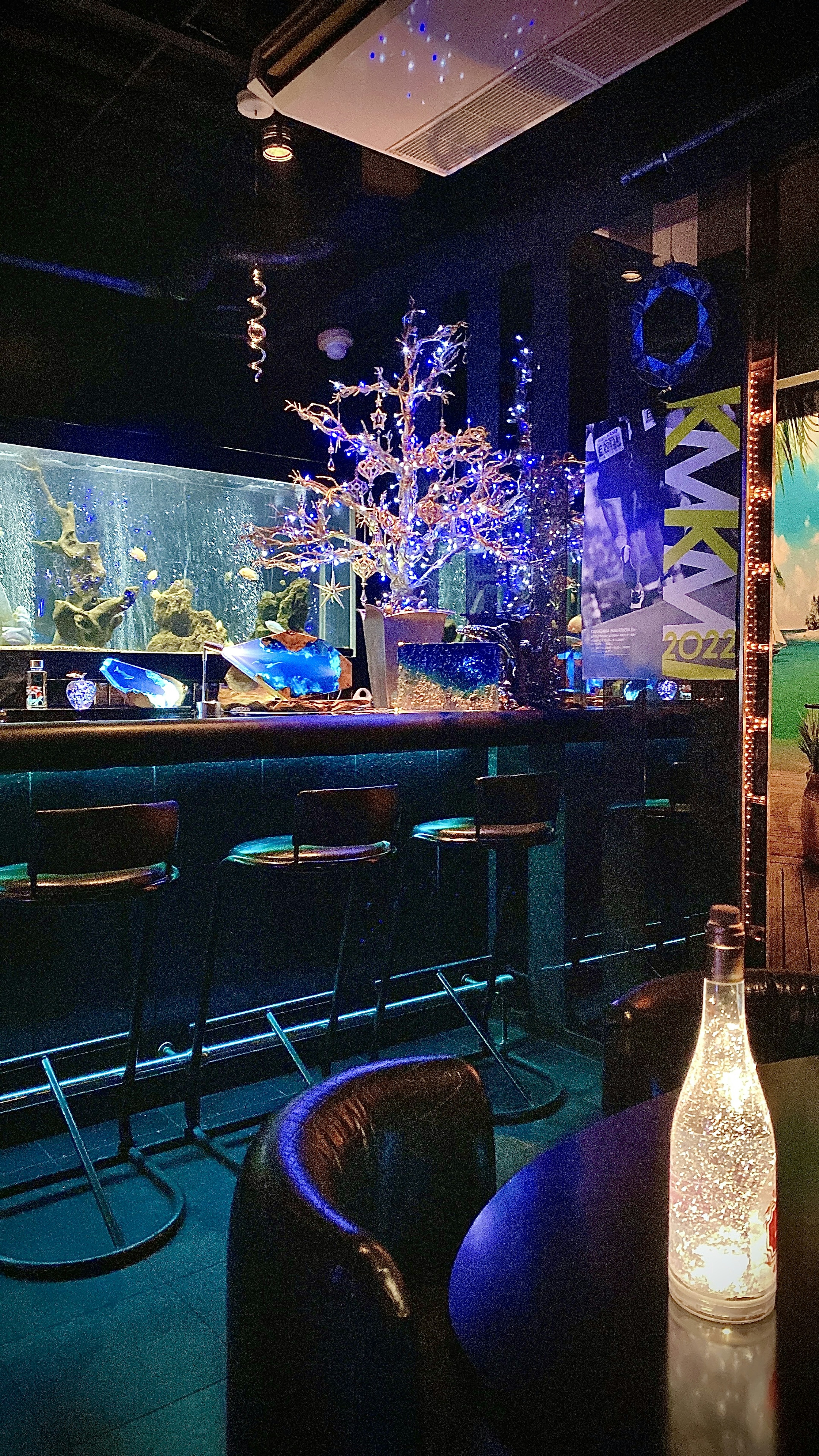 Inneneinrichtung einer Bar mit einem Aquarium und einem dekorativen Baum bei gedämpfter Beleuchtung