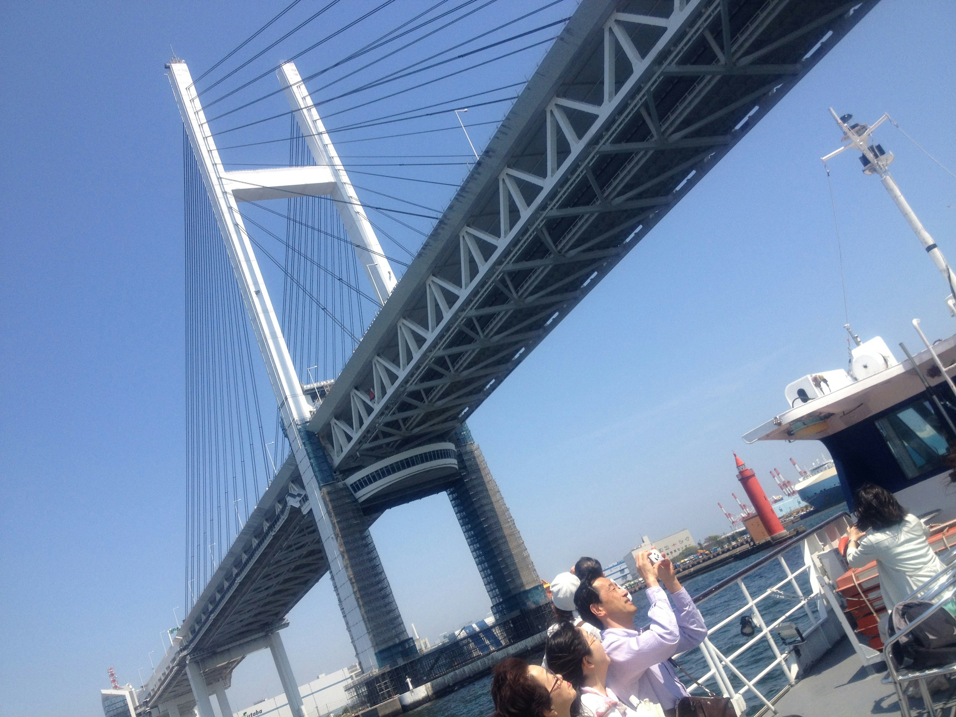 Yokohama Bay Bridge with tourists and a boat underneath