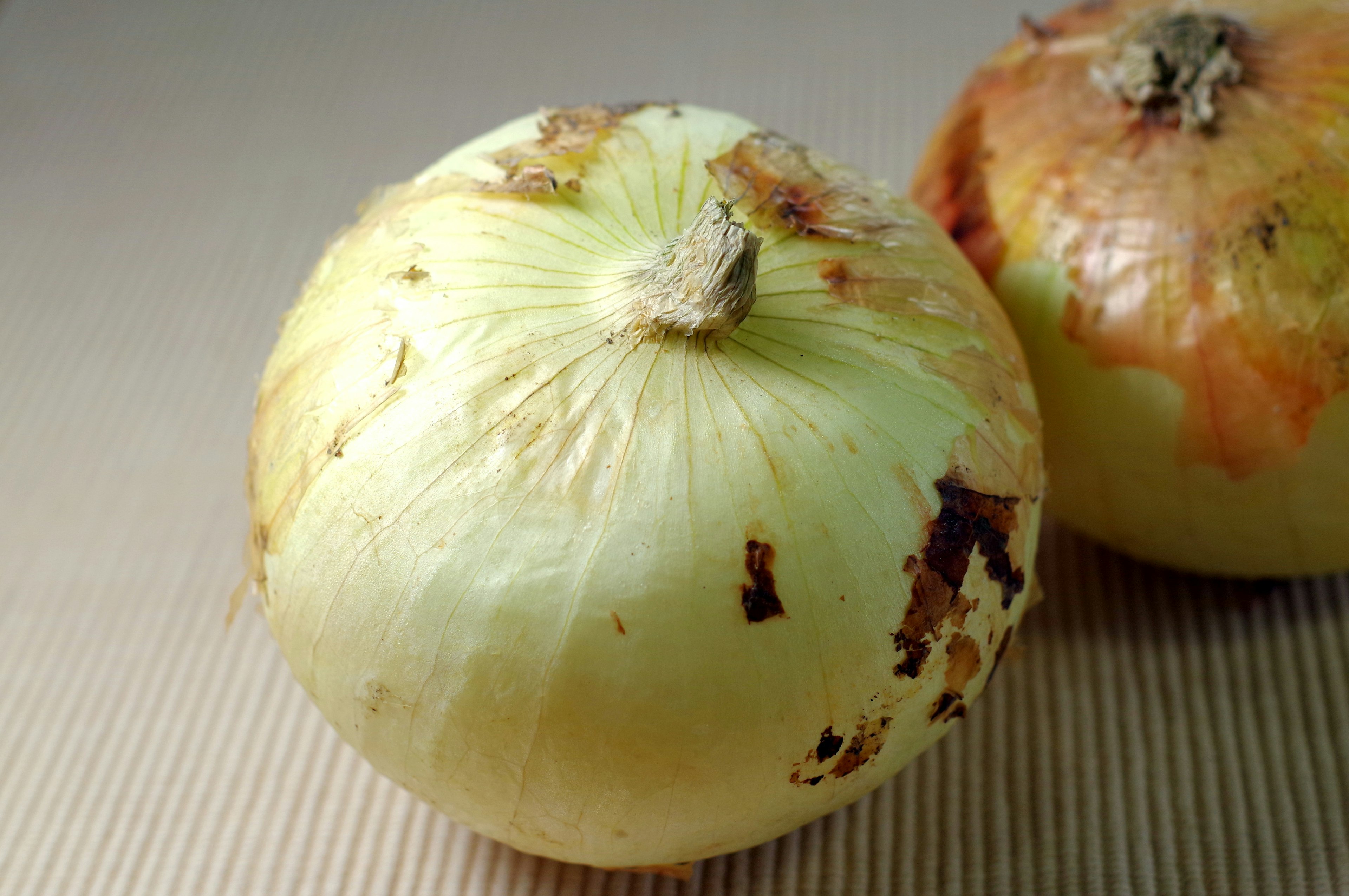 Image of two onions one is light yellow and the other is orange-tinged