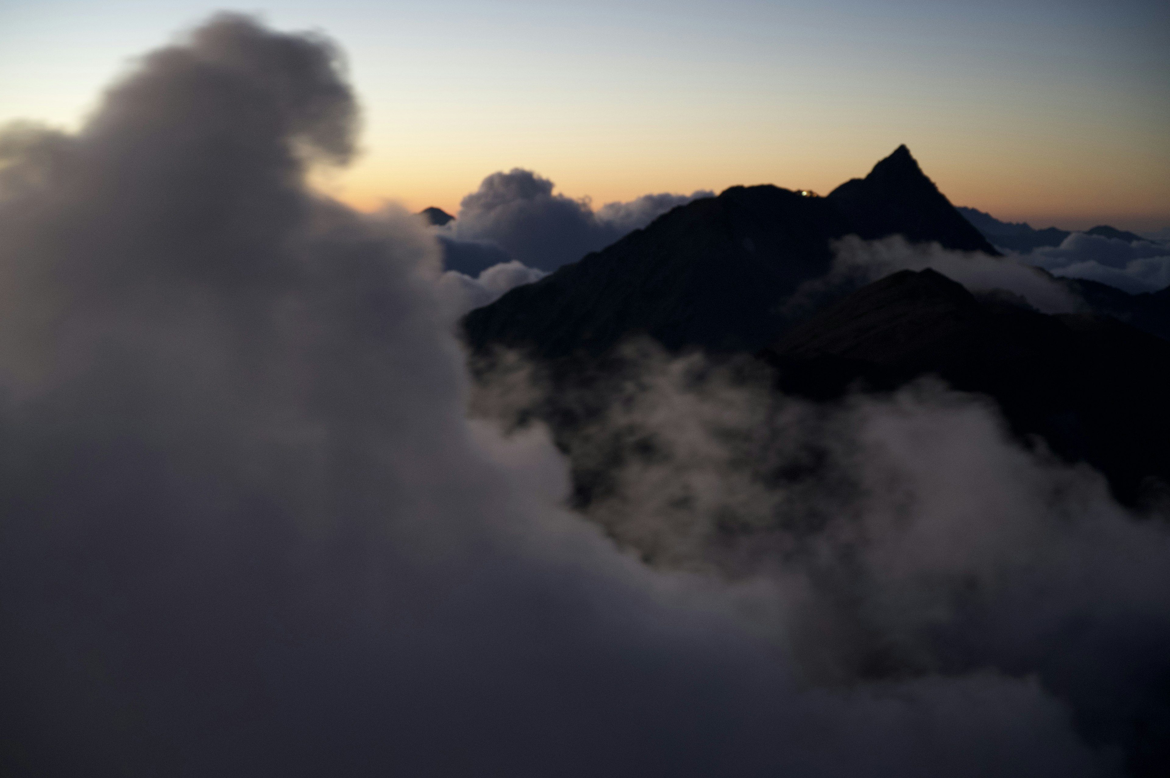 夕陽下雲霧繚繞的山脈輪廓