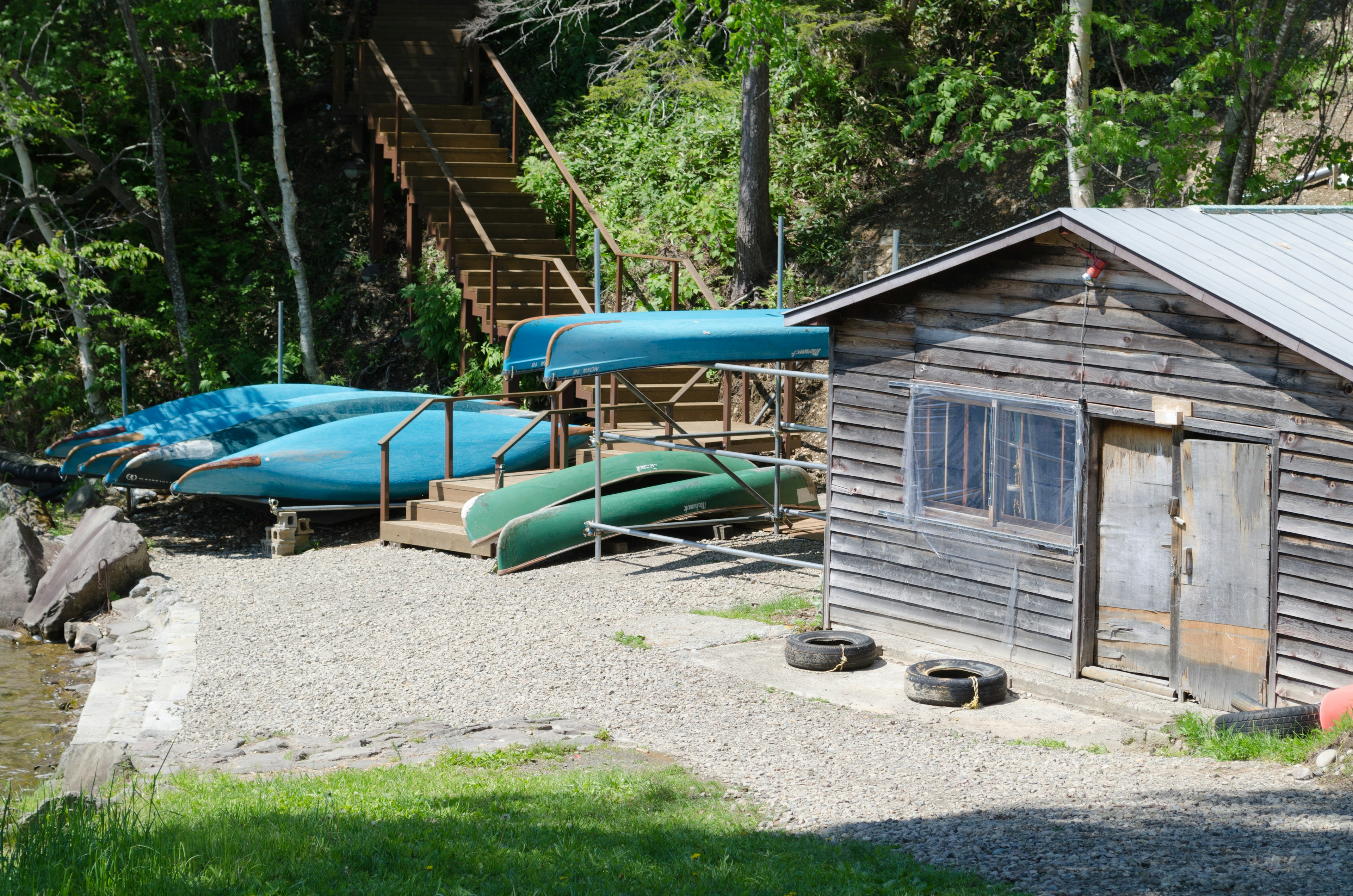 Lakeside scene with a wooden cabin and parked canoes