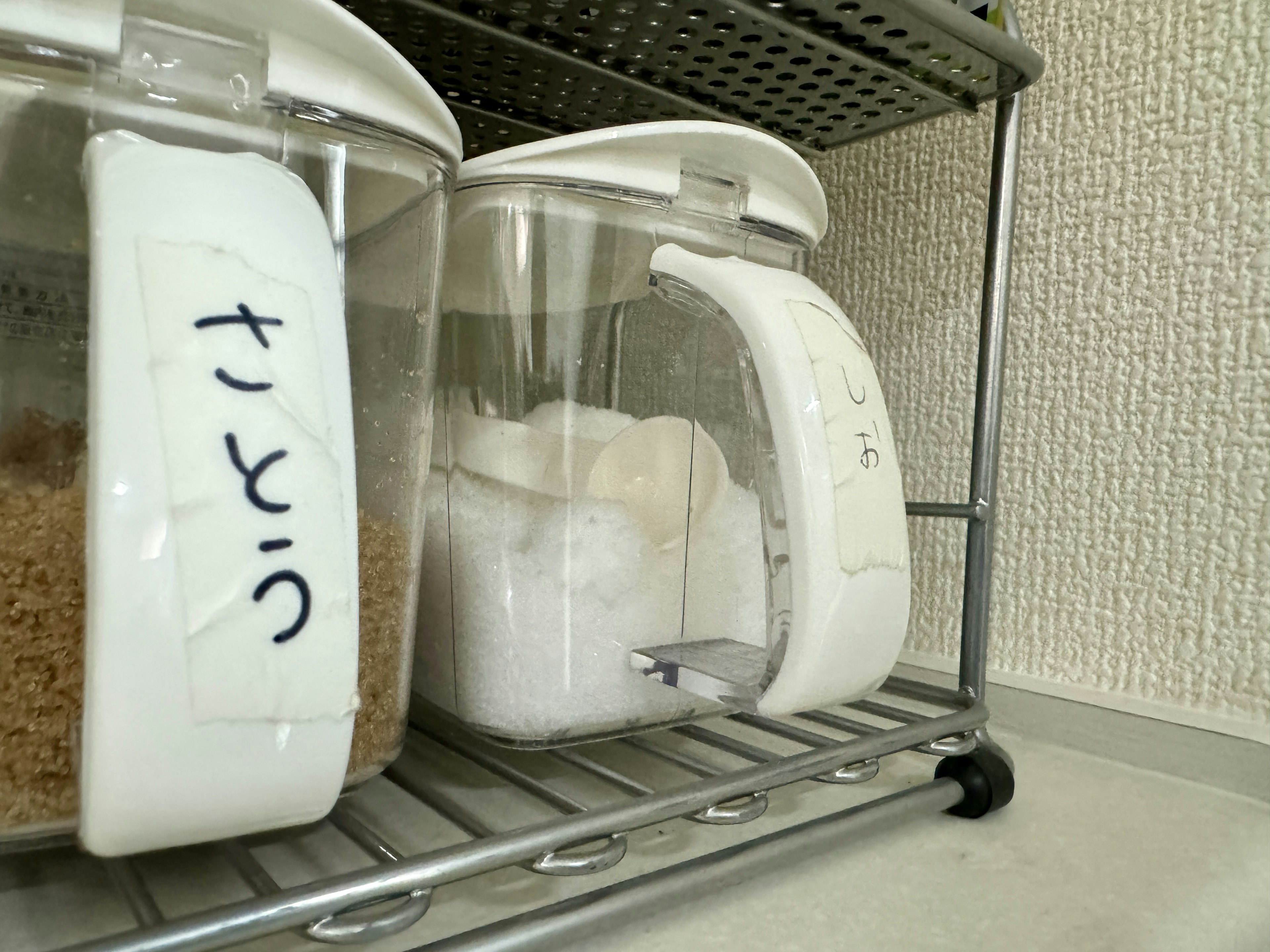 White container with sugar and brown container labeled for sugar storage