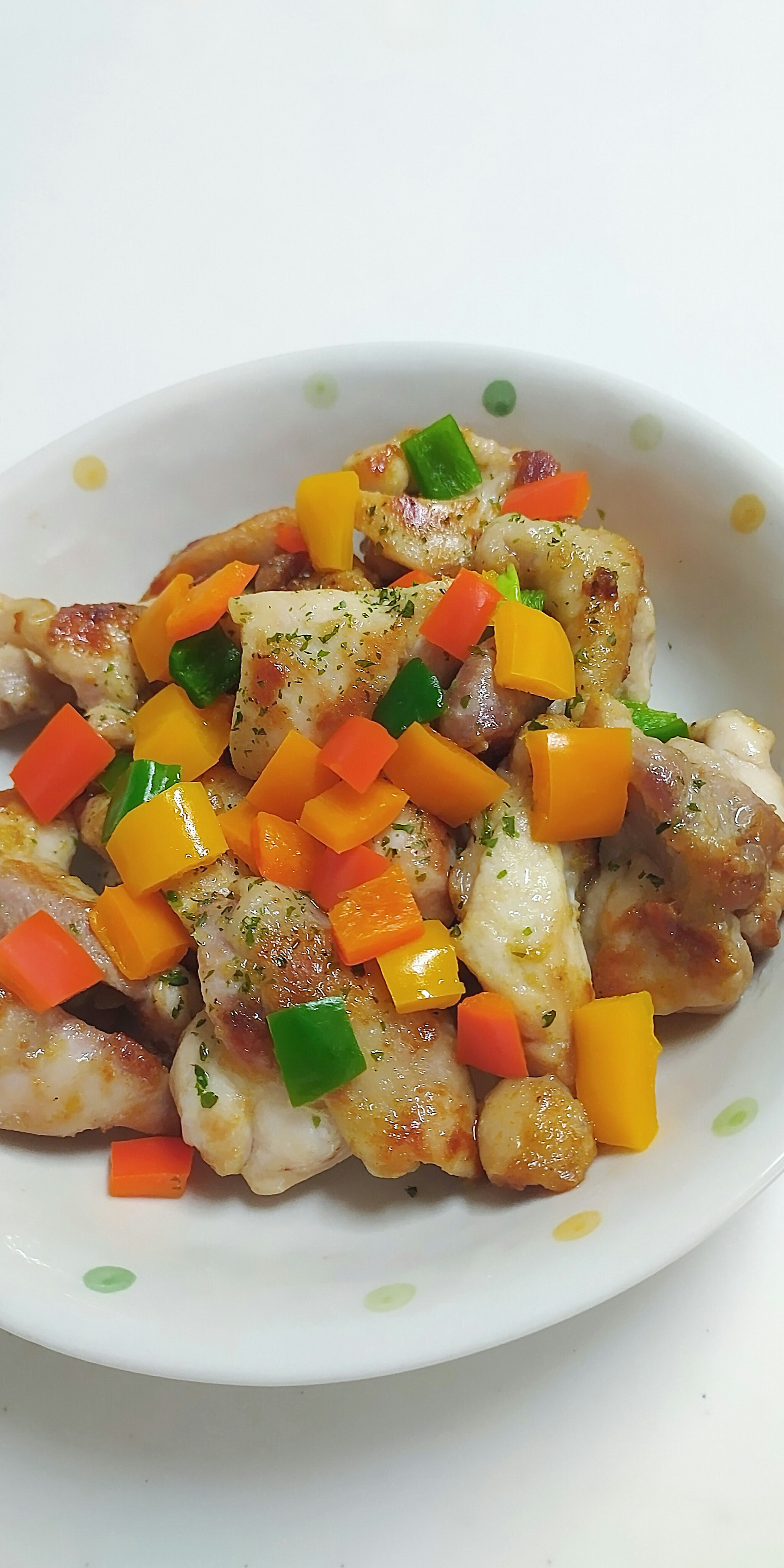 Chicken dish topped with colorful vegetables