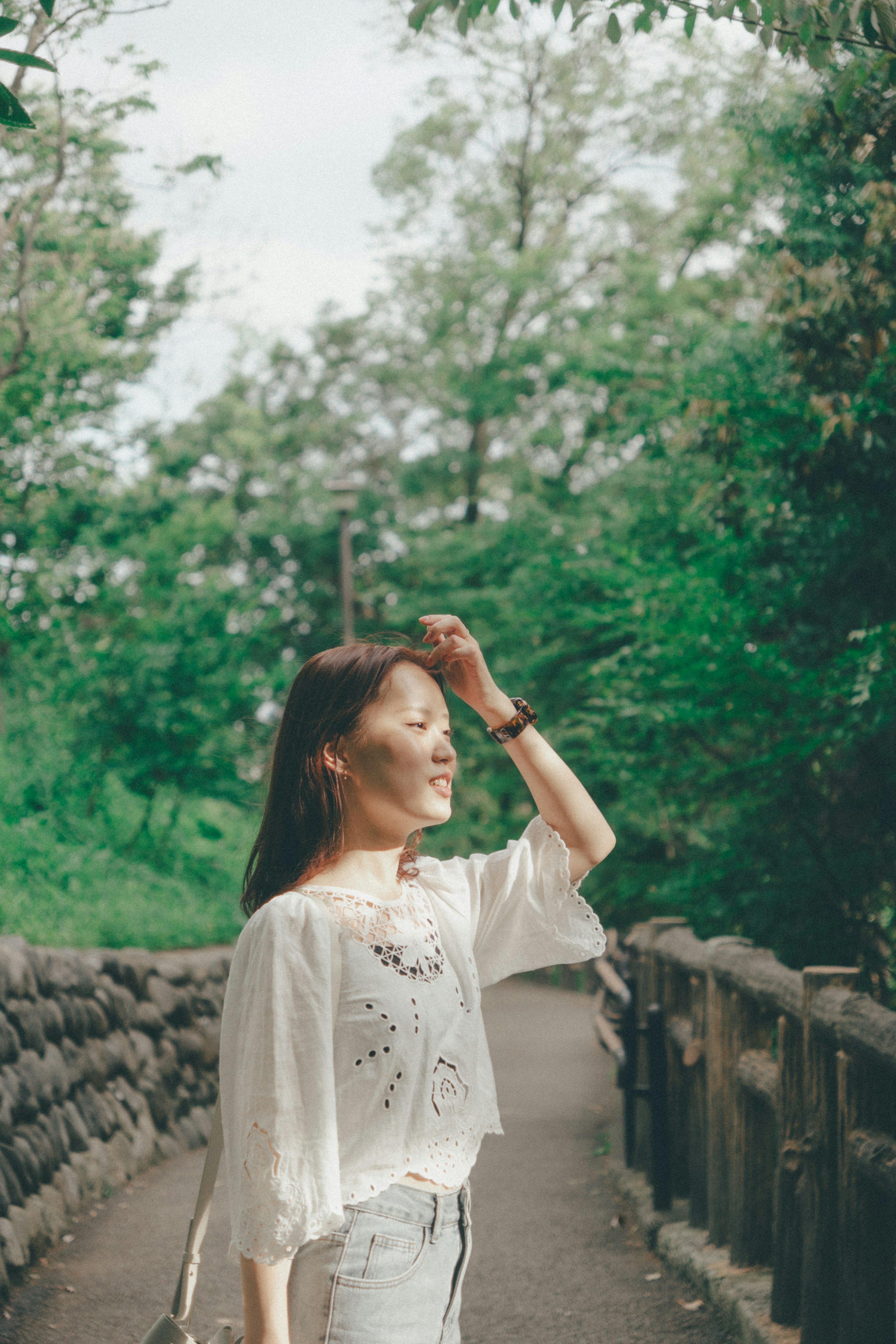 女性が緑豊かな道を歩いている風景