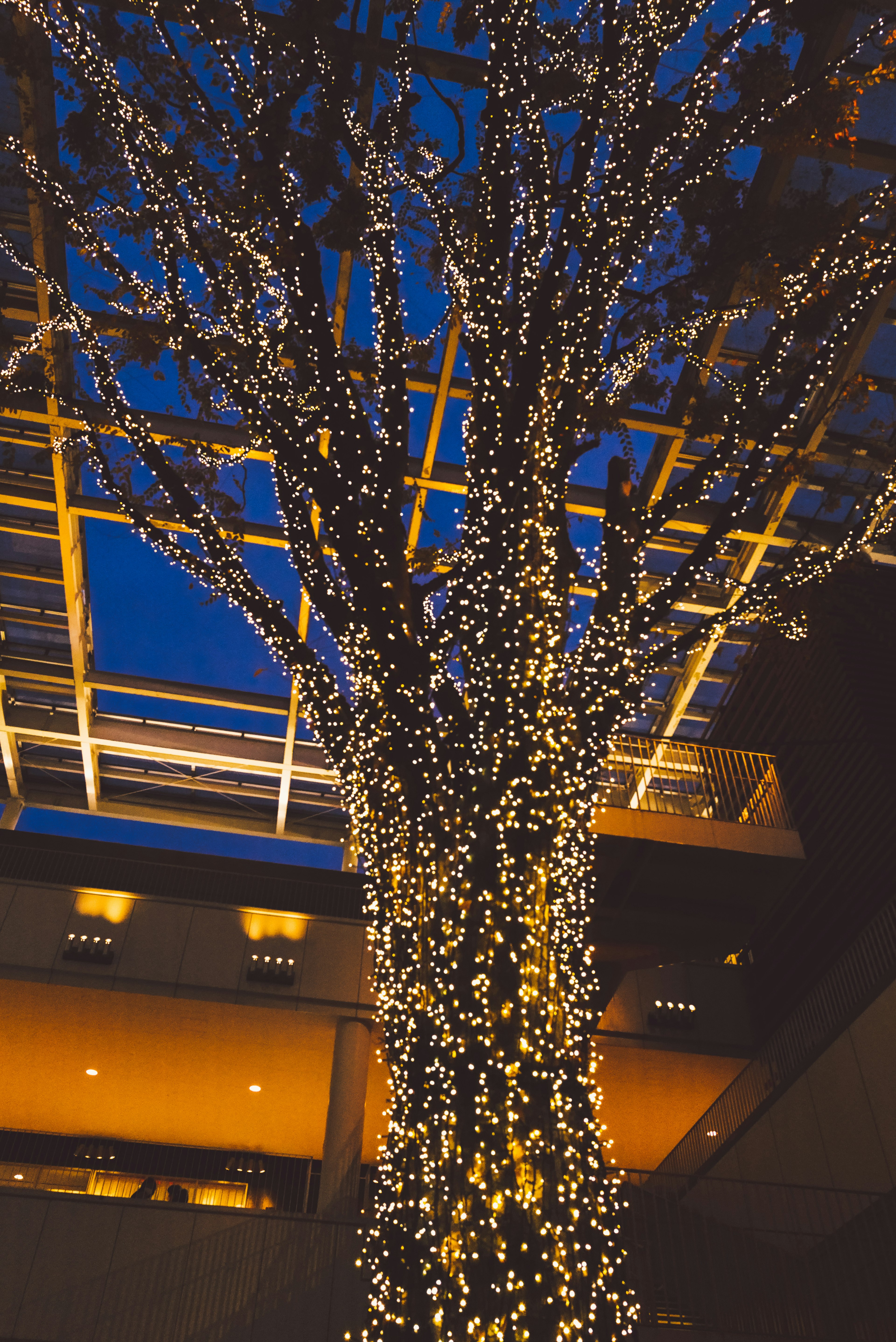 A large decorative tree trunk illuminated with lights under a blue sky