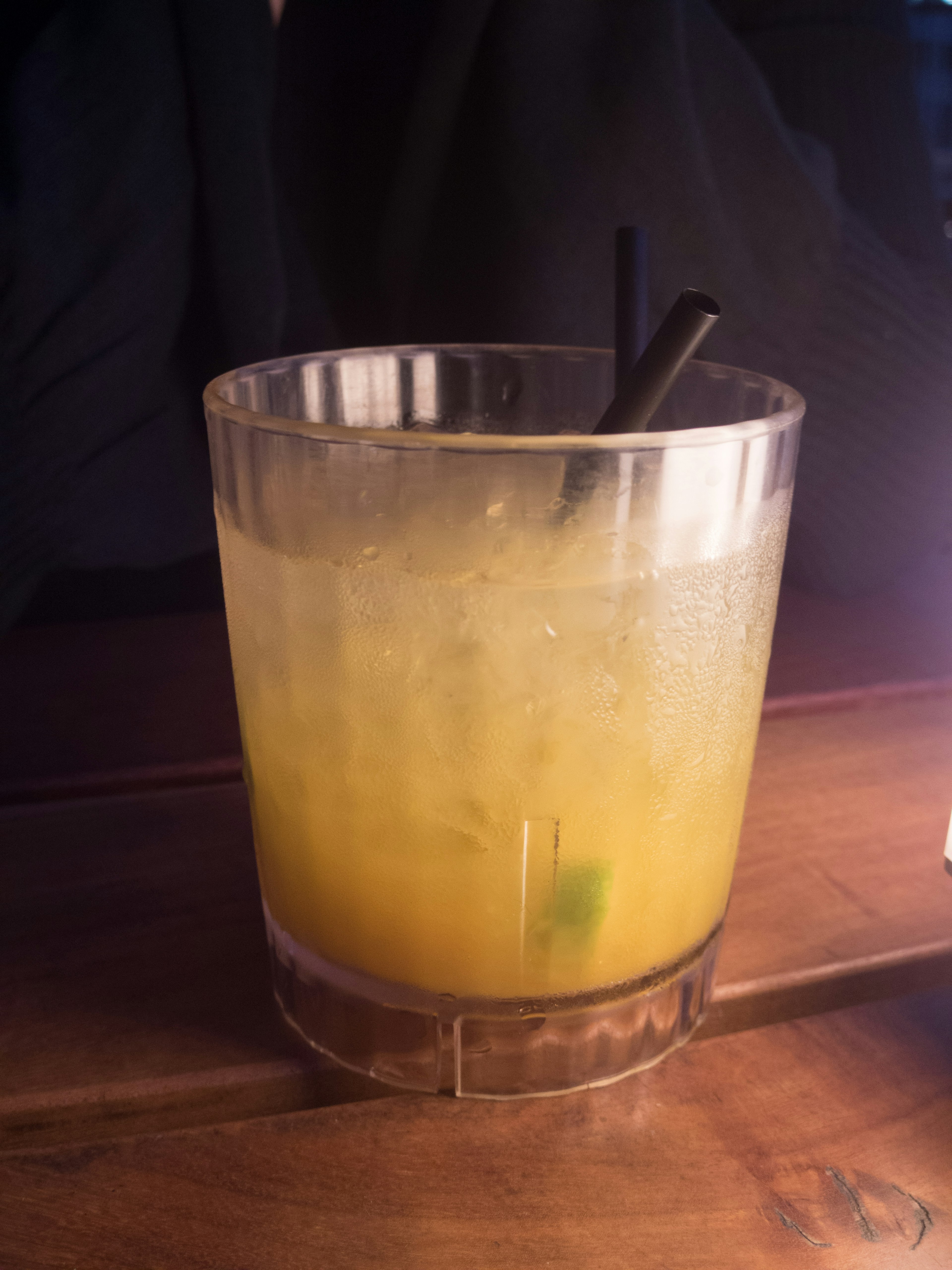 Orange cocktail in a clear glass with a straw