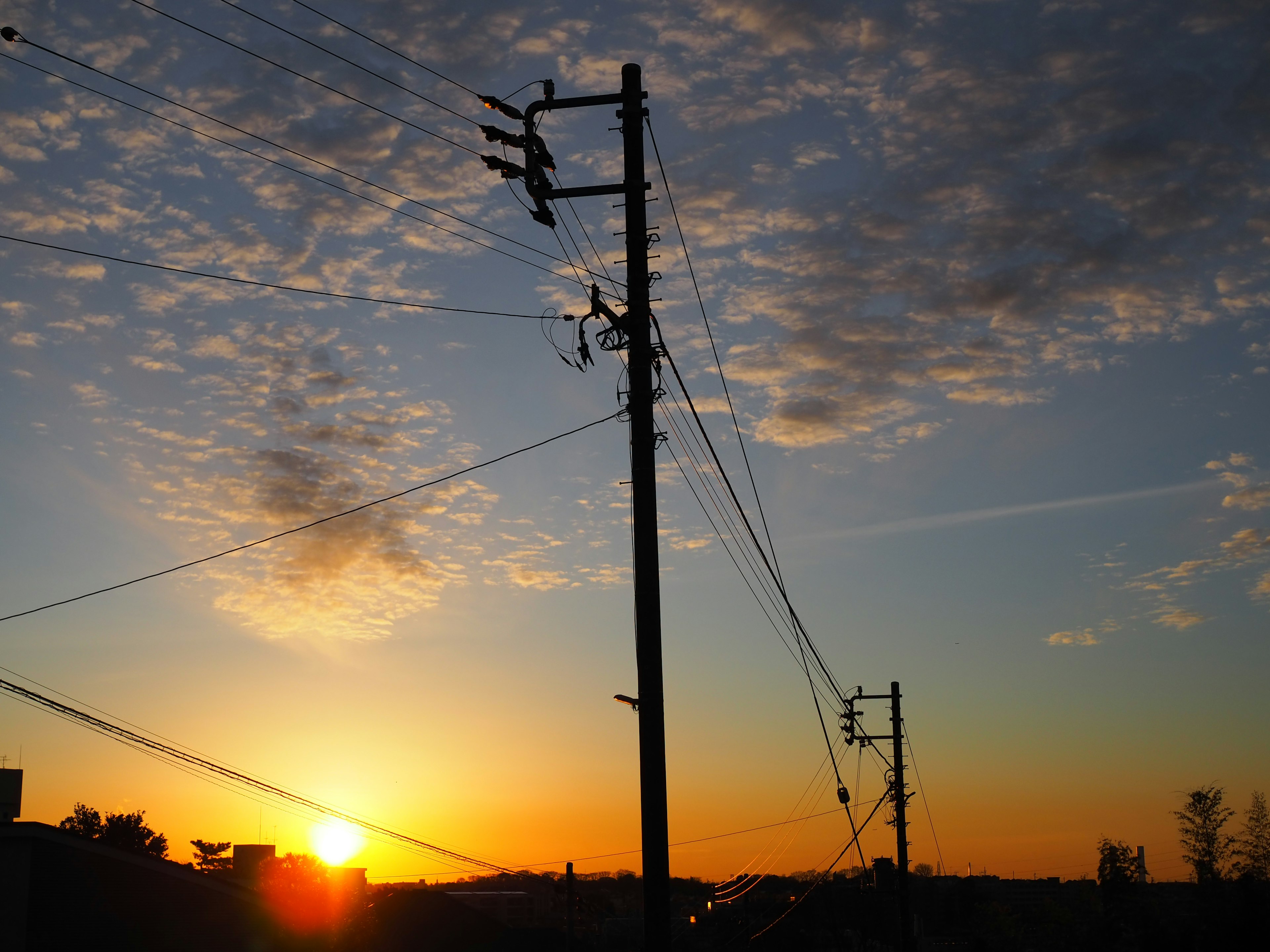 夕日が沈む空と電柱のシルエット