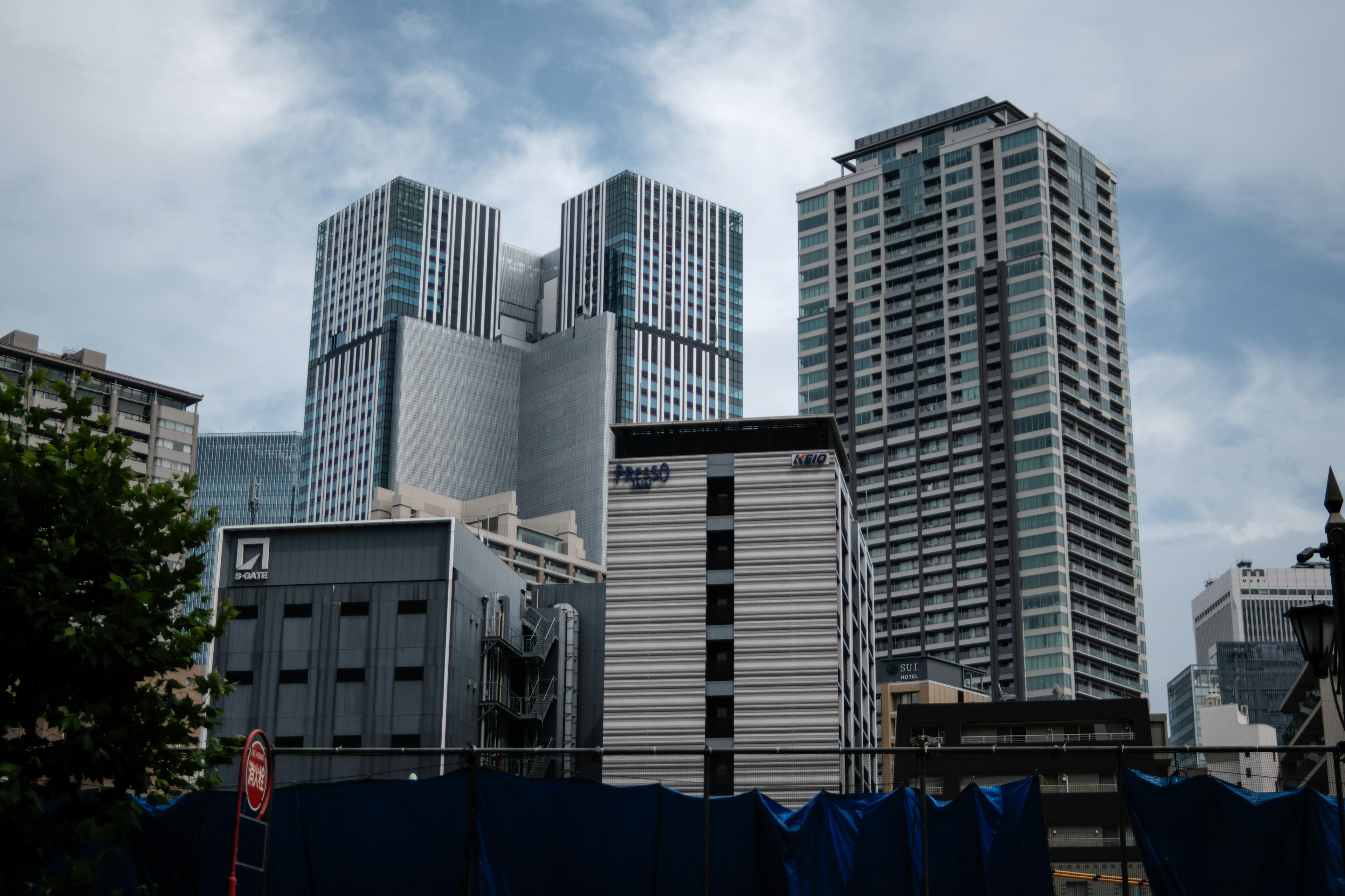 Urban skyline featuring tall buildings with a cloudy sky