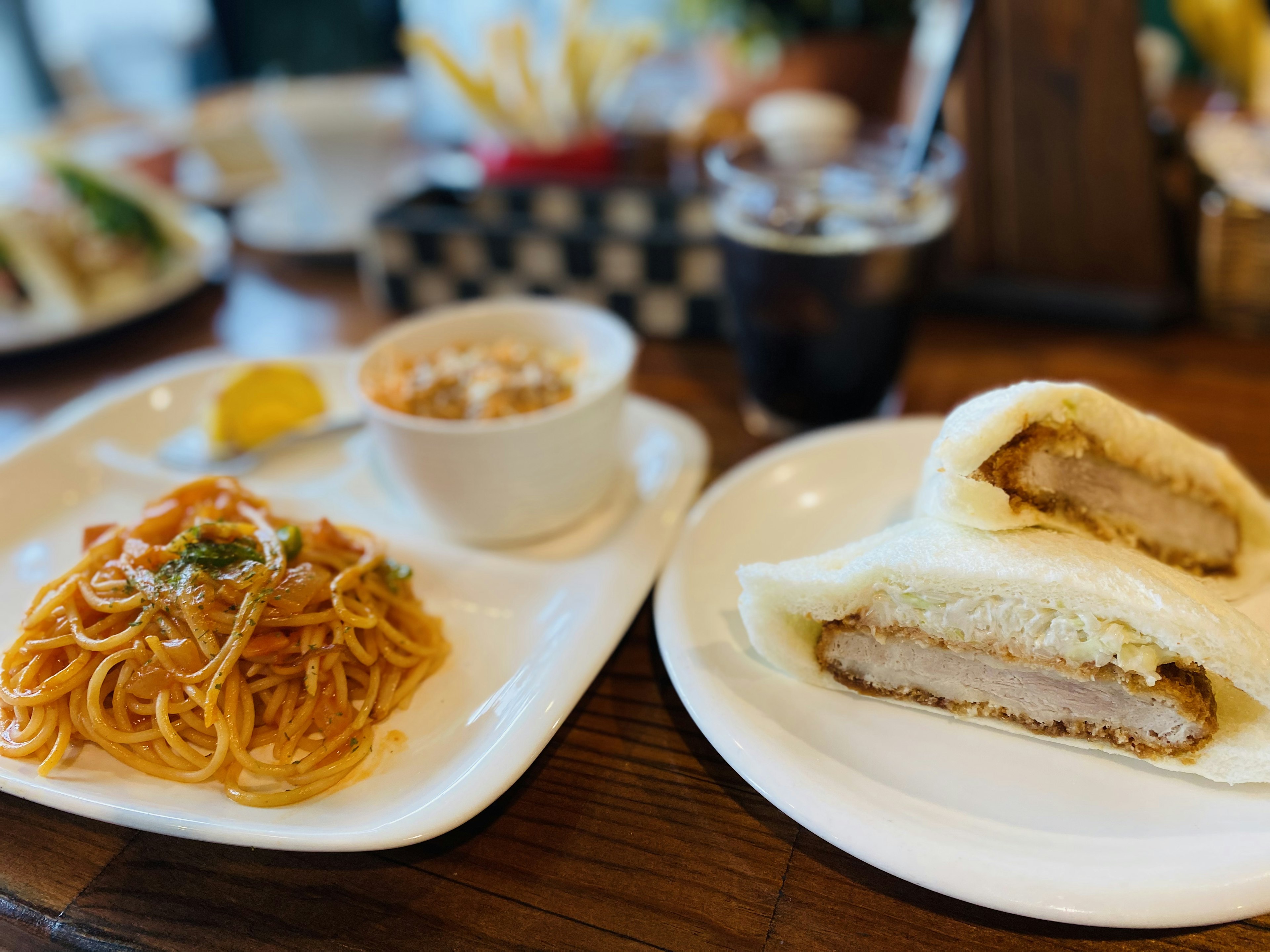 皿に盛られたスパゲッティとフライドチキンのサンドイッチ