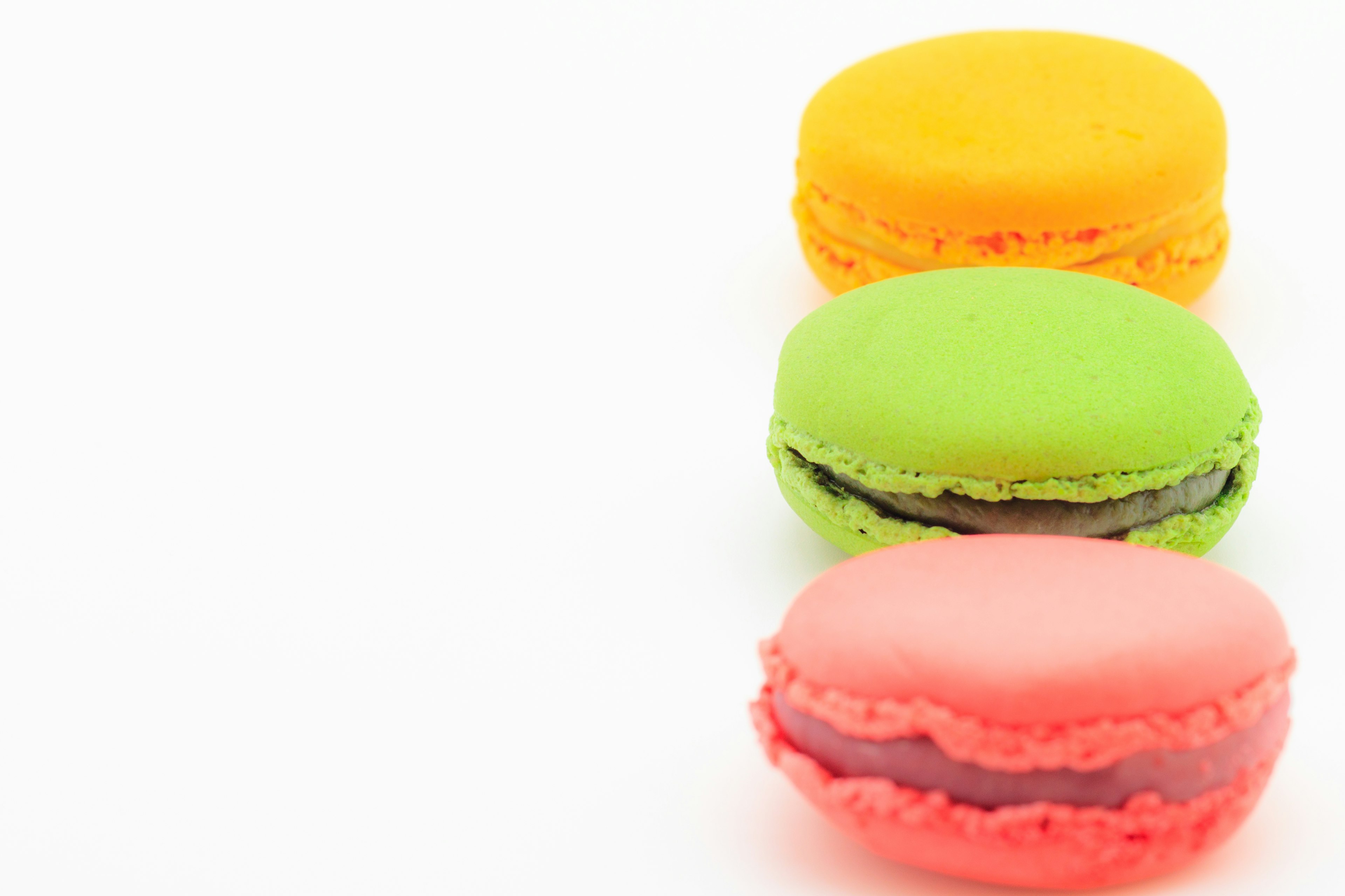 Bunte Macarons in einer Reihe angeordnet gelb grün rosa