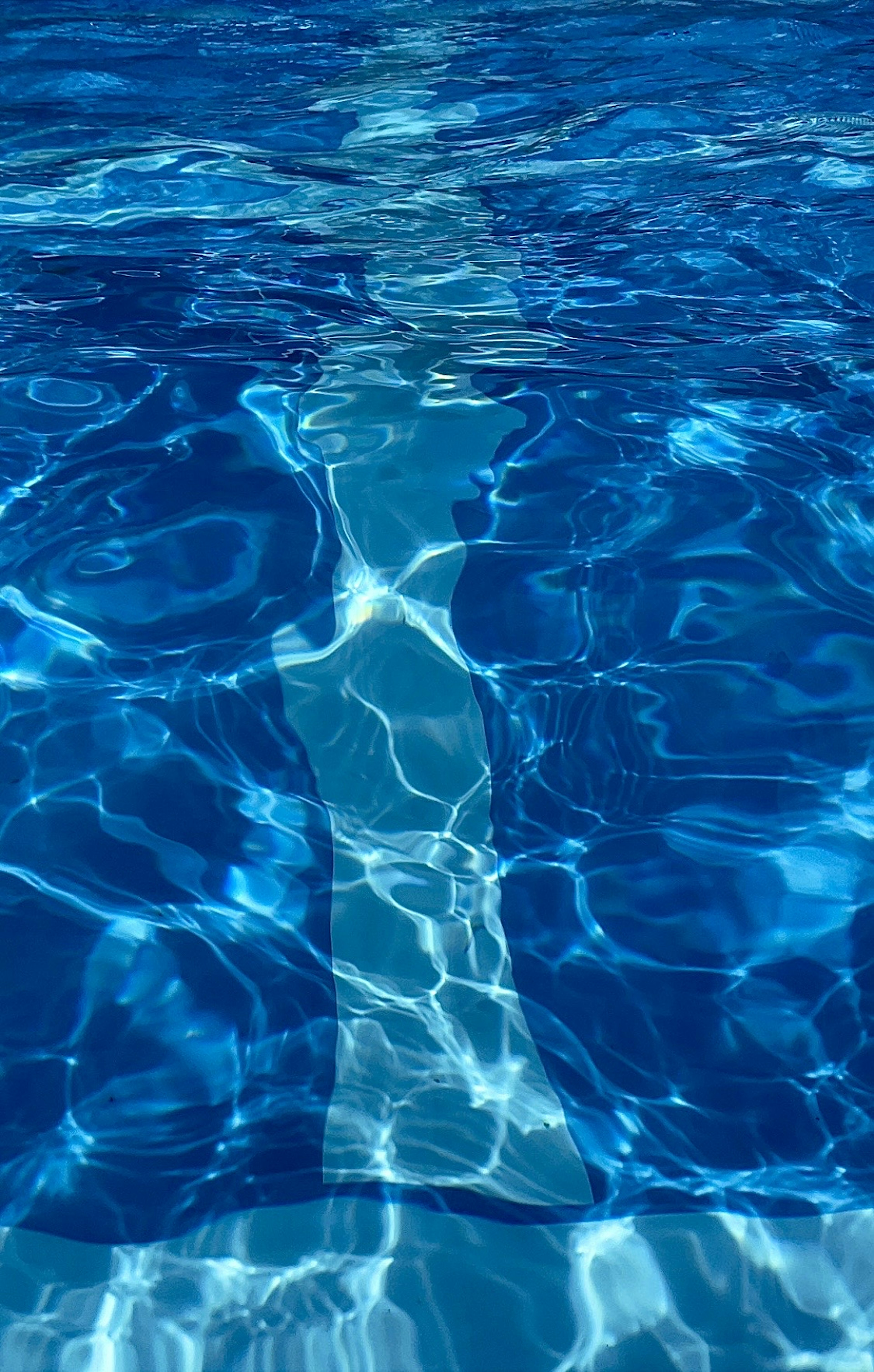 Surface d'eau bleue ondulante avec des reflets de lumière