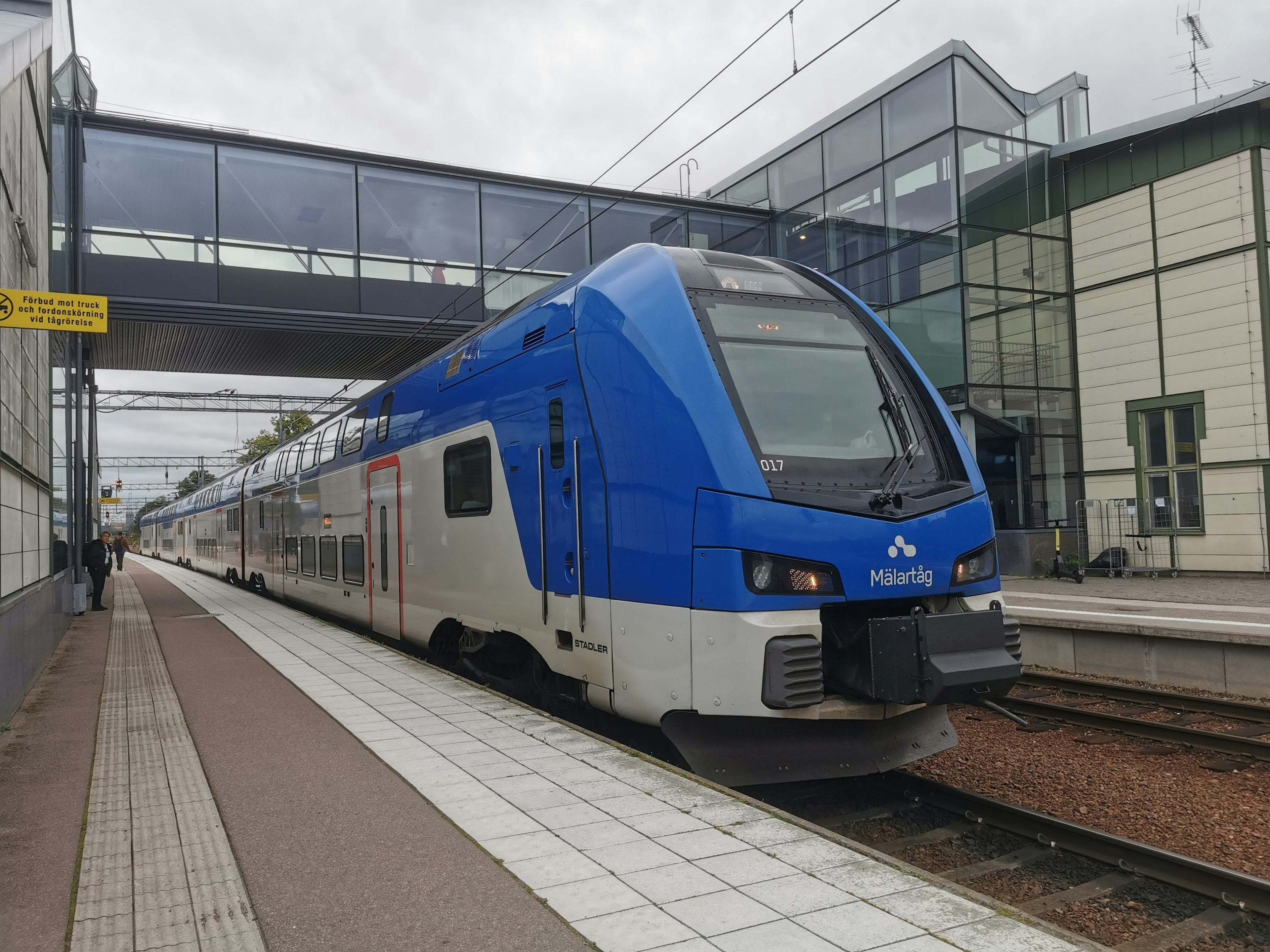 Modern blue and white train stopped at a railway station platform