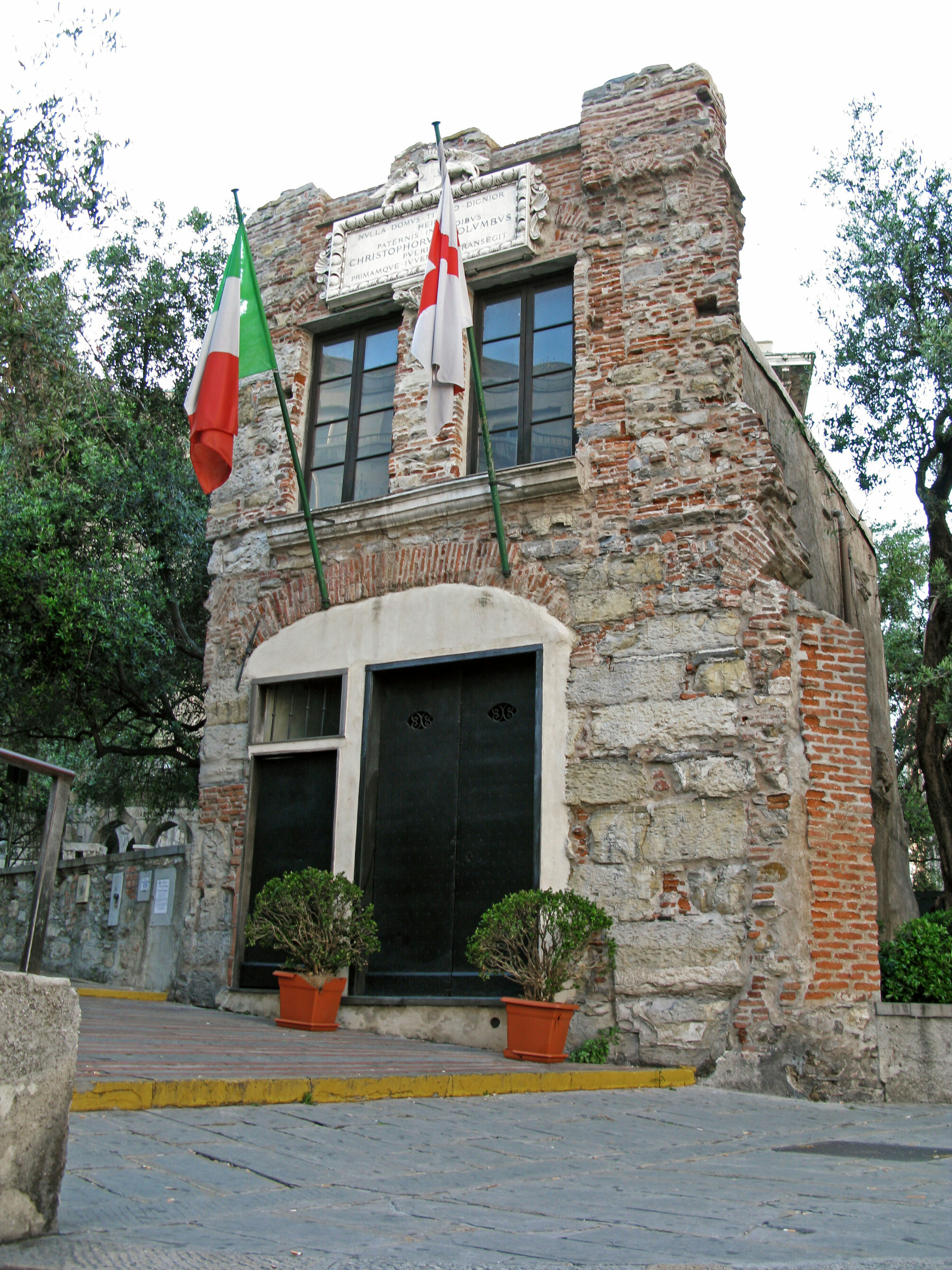 Vecchio edificio in pietra con bandiere italiana e di San Giorgio