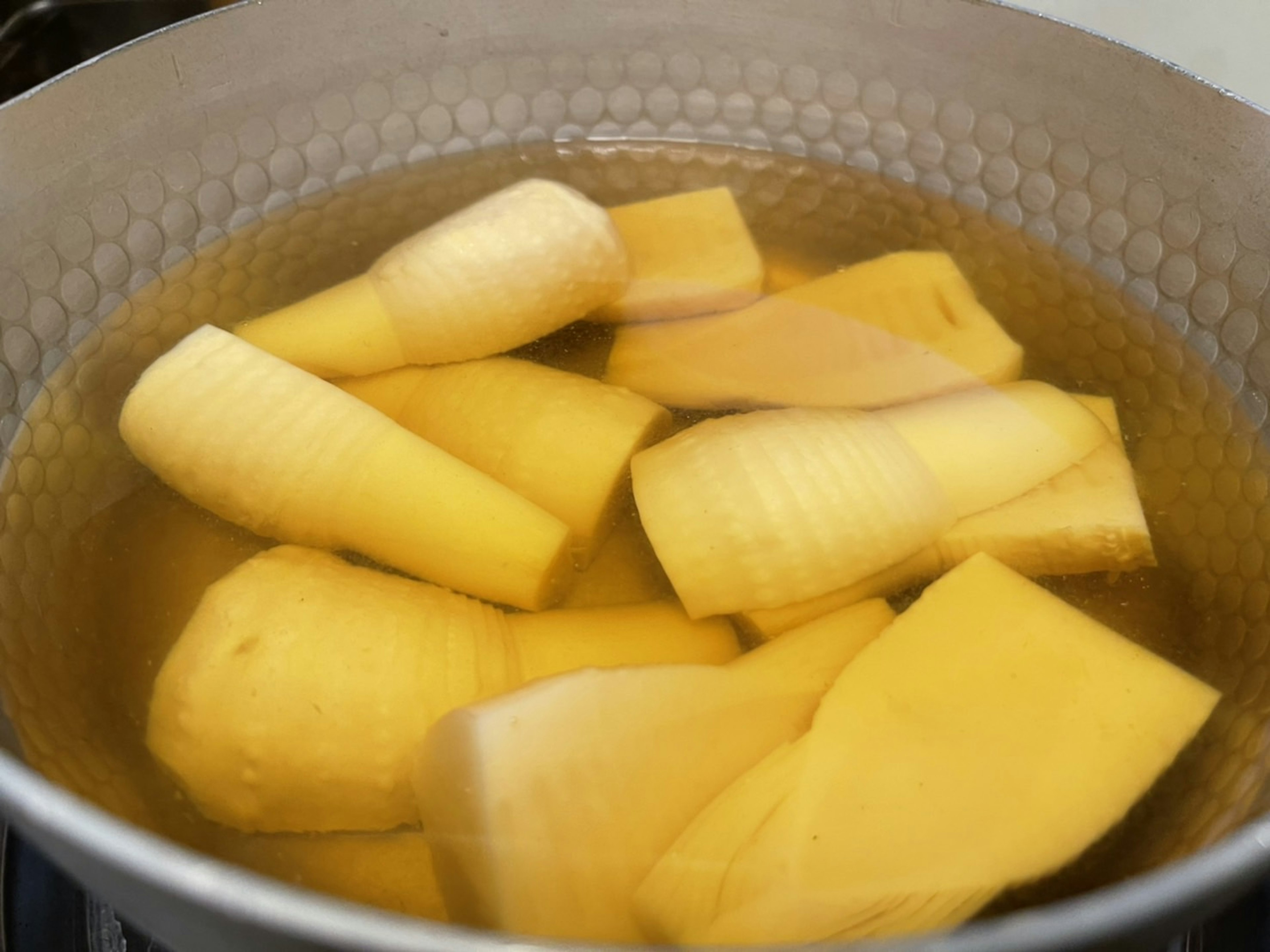 Slices of yellow bananas boiling in a pot