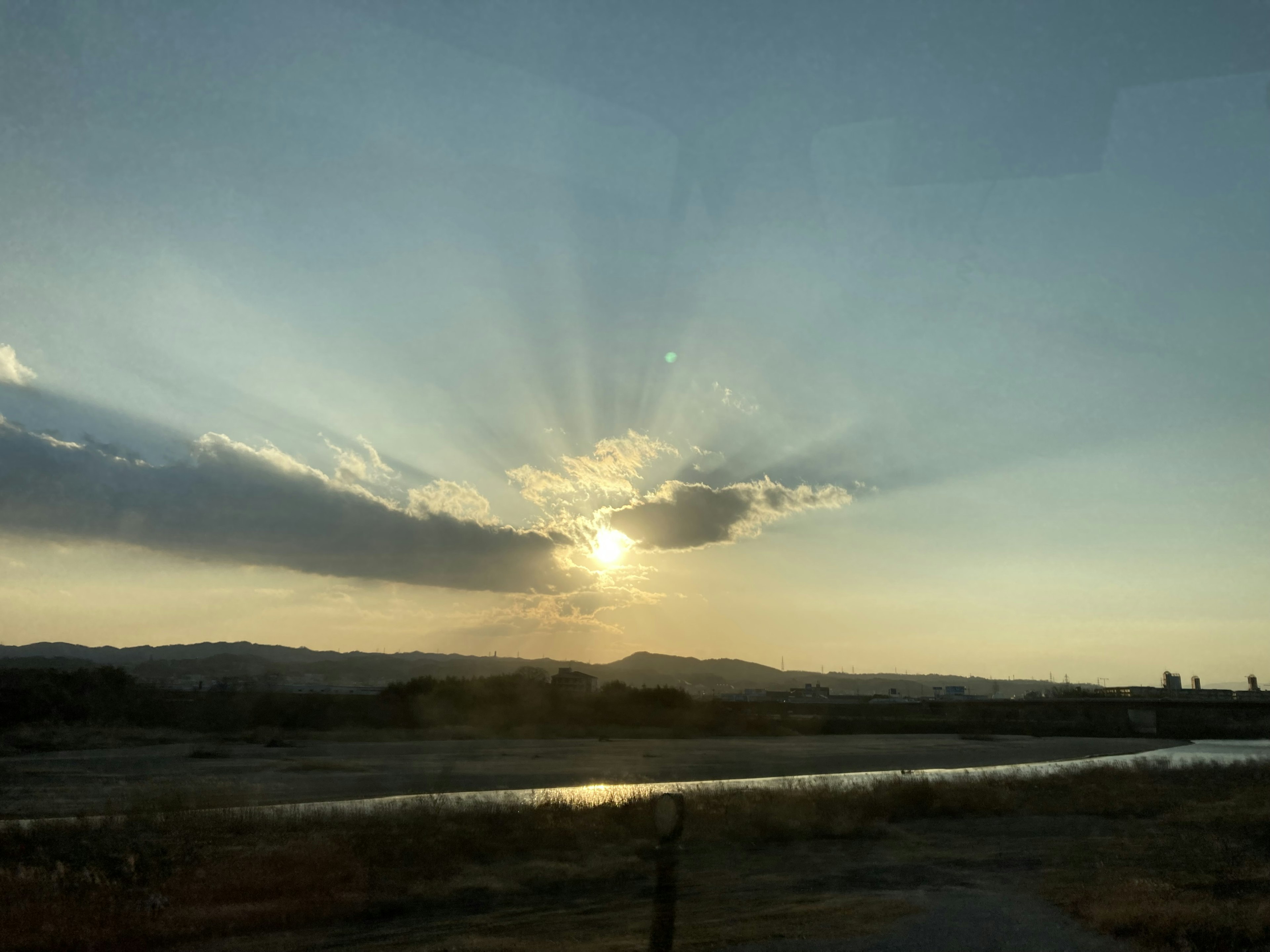 Hermoso paisaje con rayos de atardecer brillando a través de las nubes